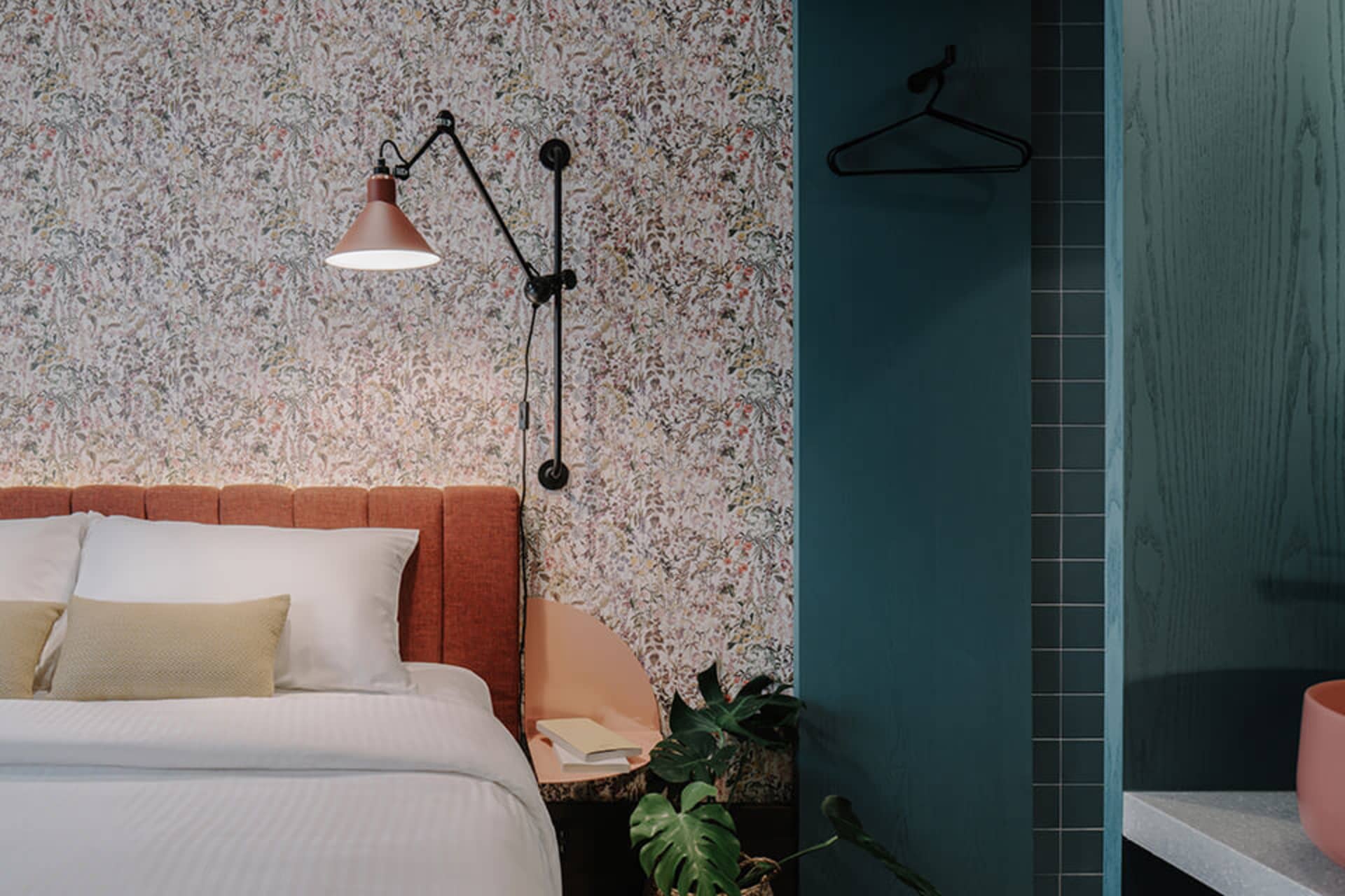 A modern bedroom featuring a floral patterned wallpaper and a comfortable bed.