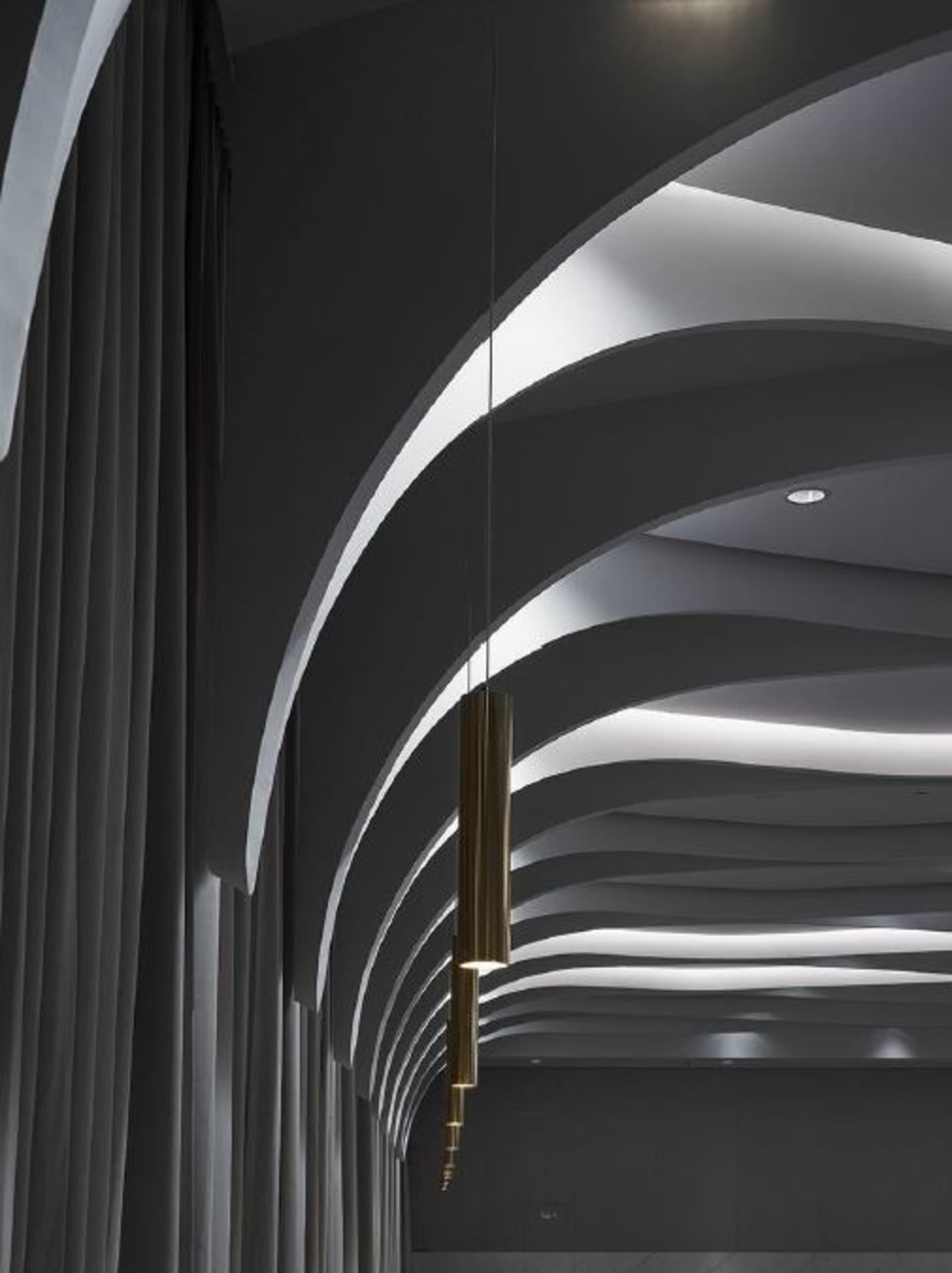 A modern interior space with curved, metallic lighting fixtures.