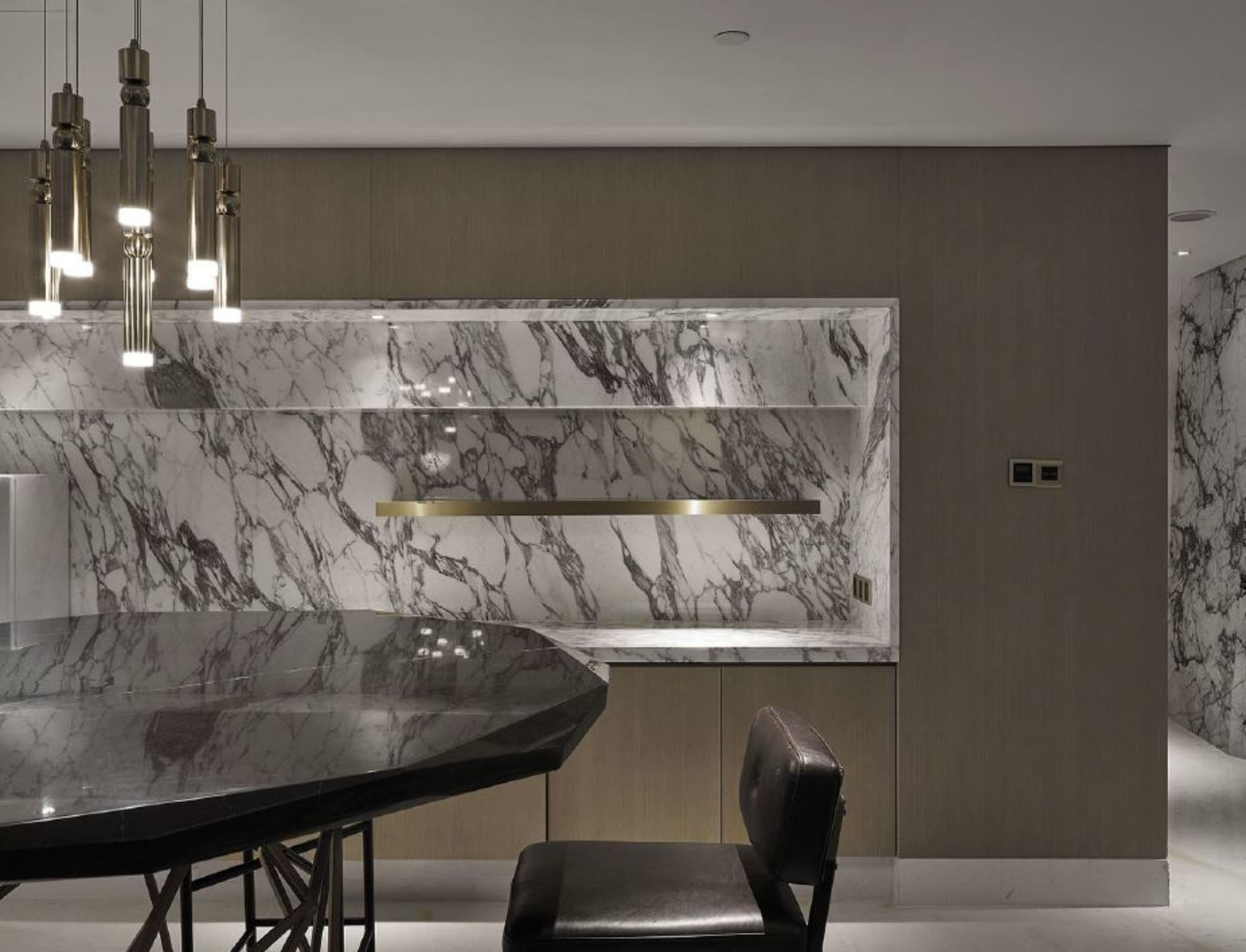 A modern kitchen featuring a marble countertop and backsplash.