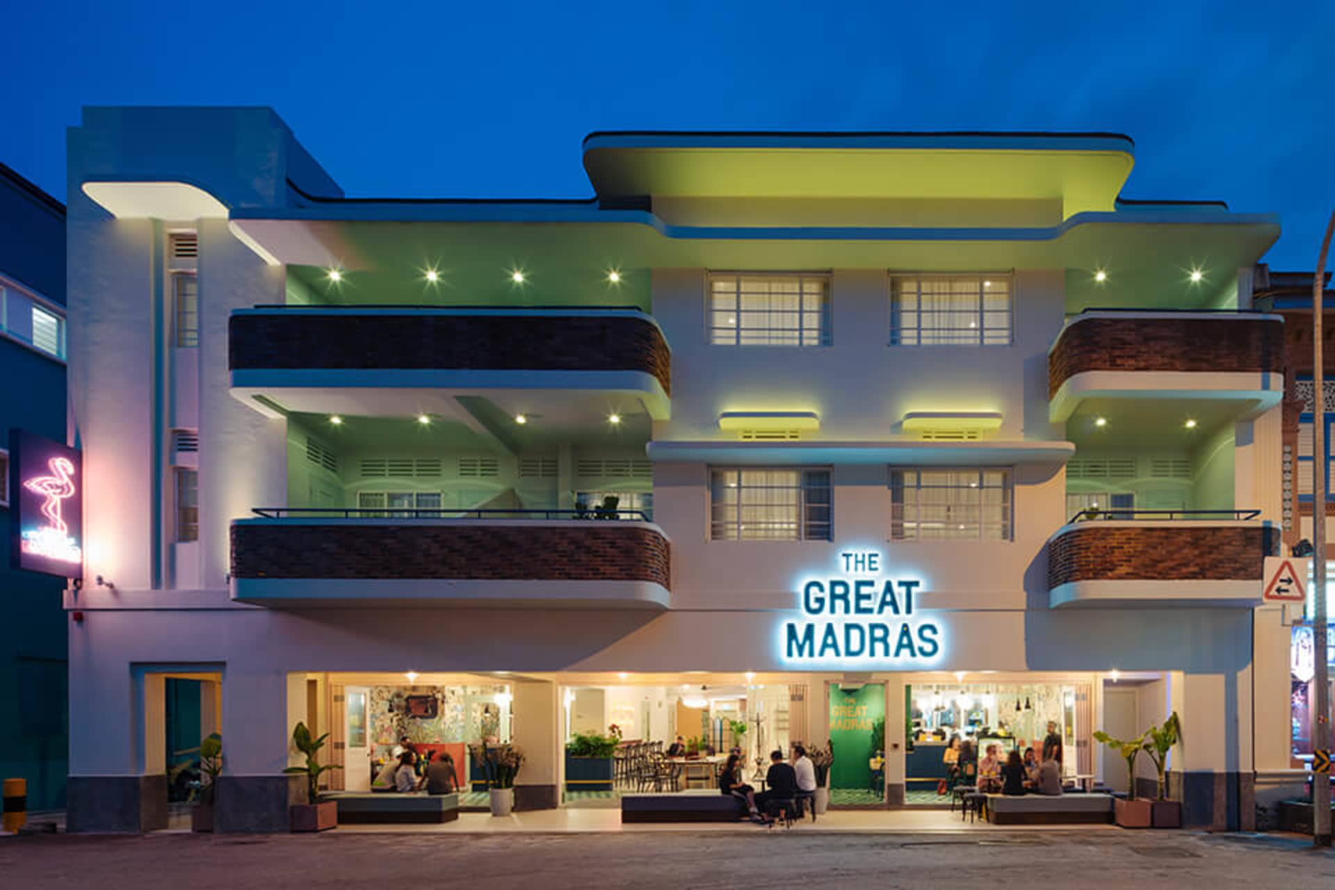 An illuminated building facade with a neon sign reading 'The Great Madras'.