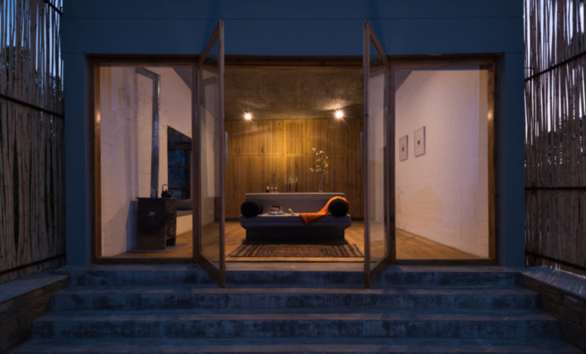 A modern bedroom interior with warm lighting and wooden elements.