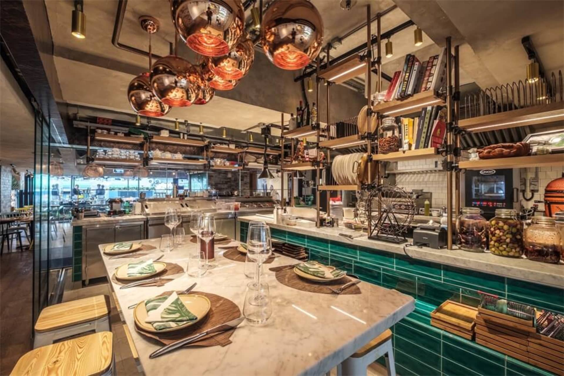 A modern restaurant interior featuring metallic decor and green tiles