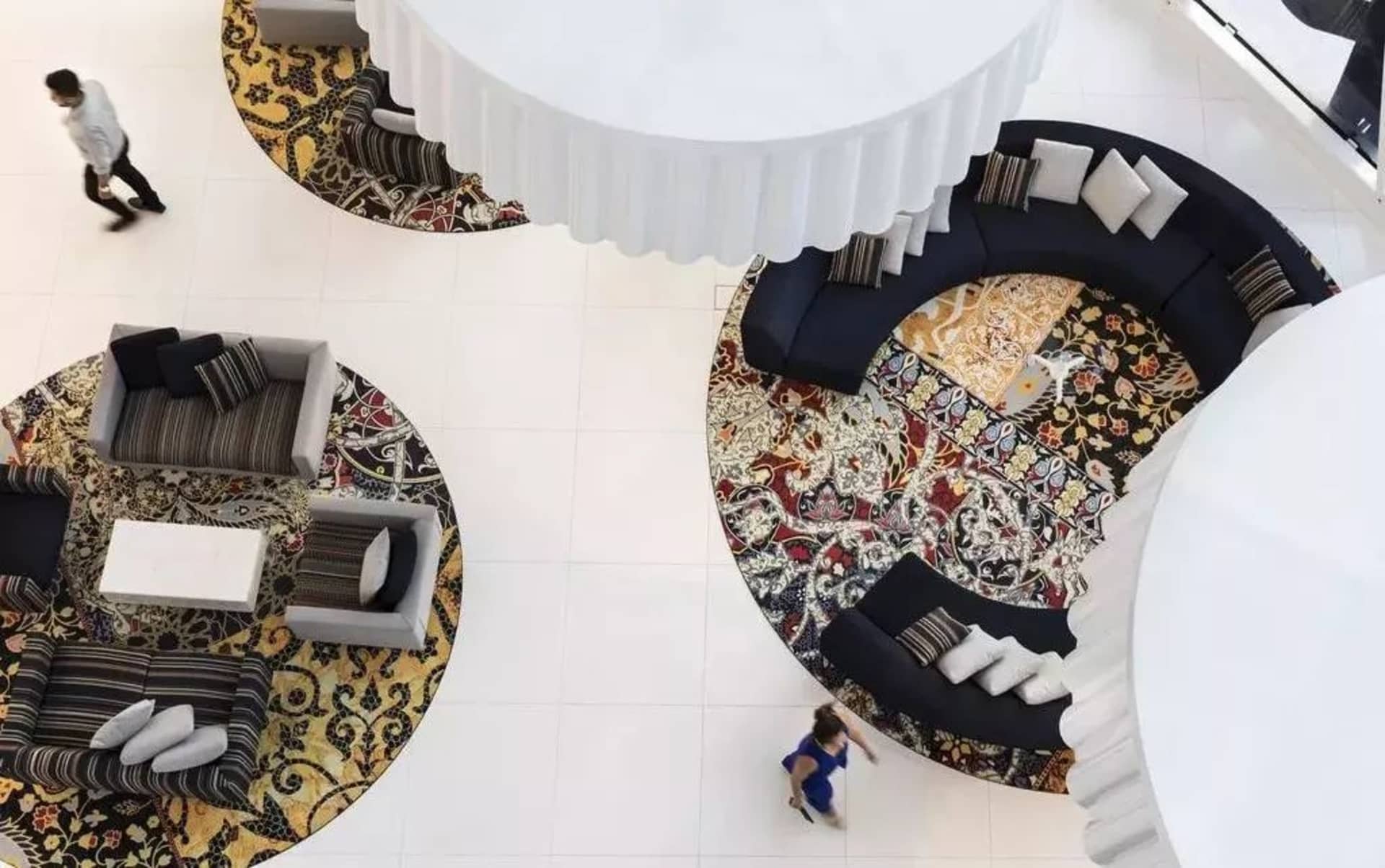 Modern hotel reception area featuring carpet and cushions