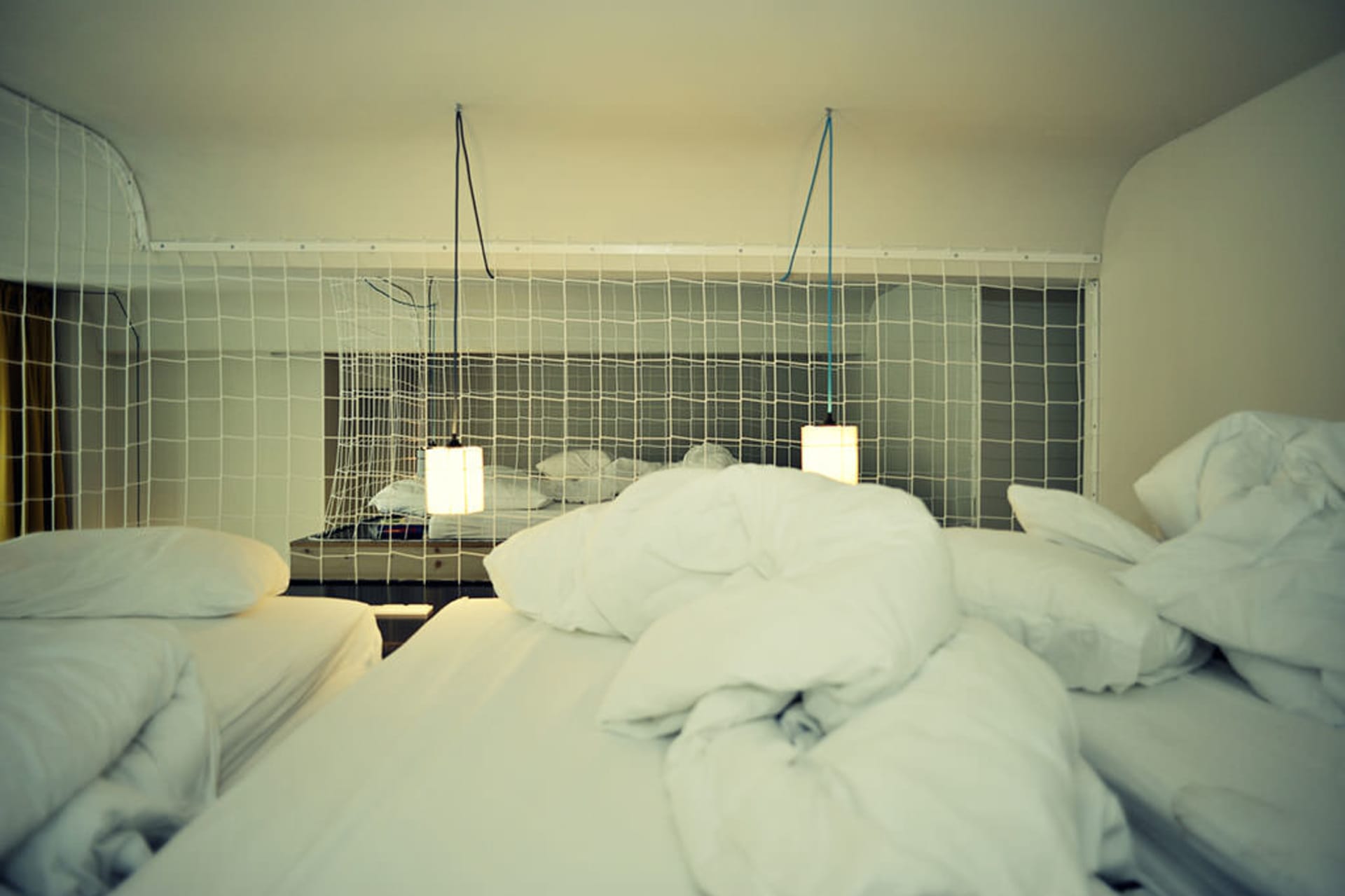 A messy bed with white pillows and blankets