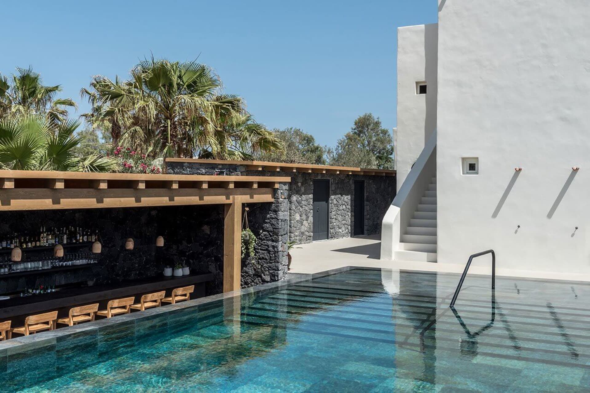 現代泳池邊吧台,搭配休閒座椅與棕櫚葉