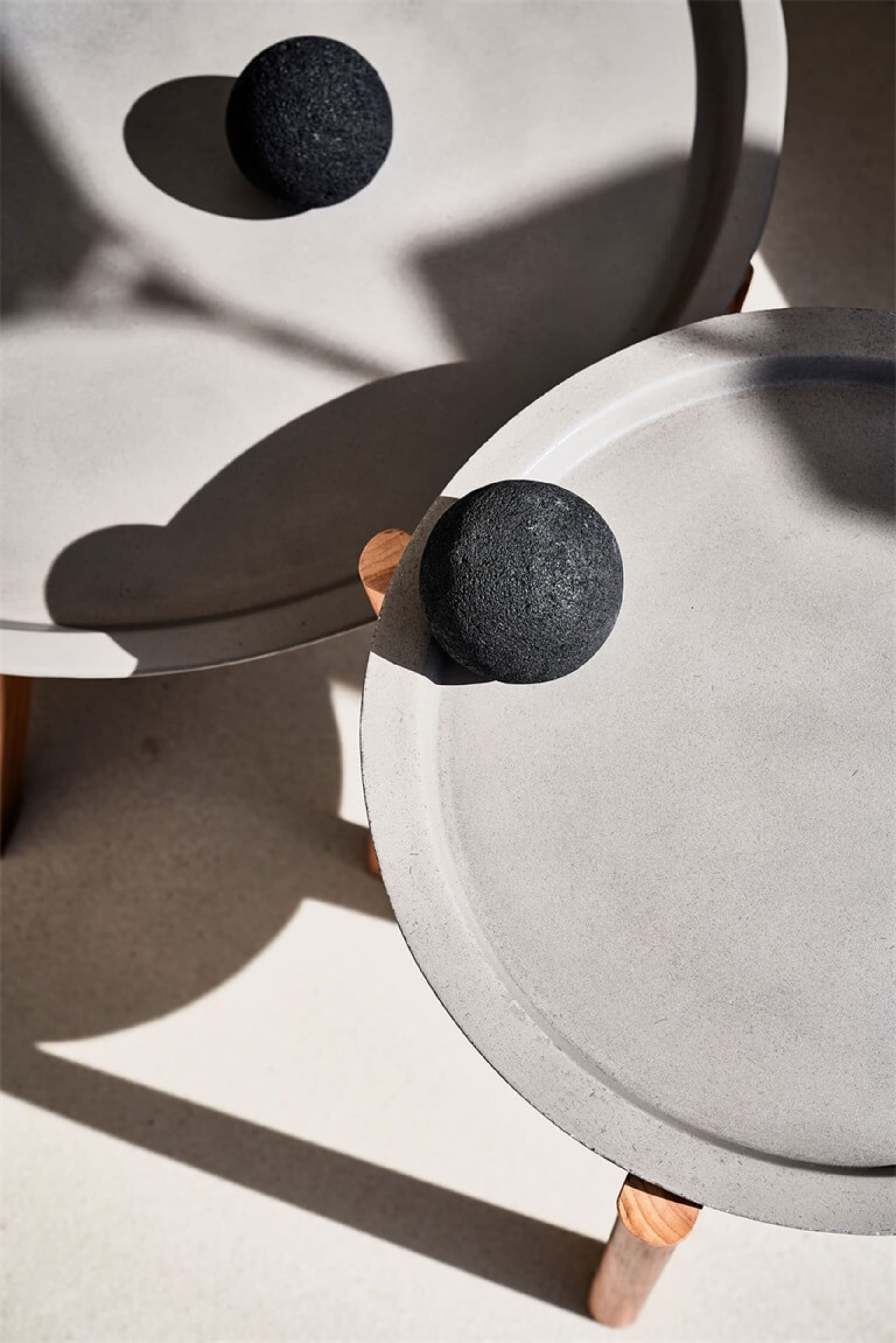 Minimalist modern side tables featuring concrete tops in a contemporary setting.