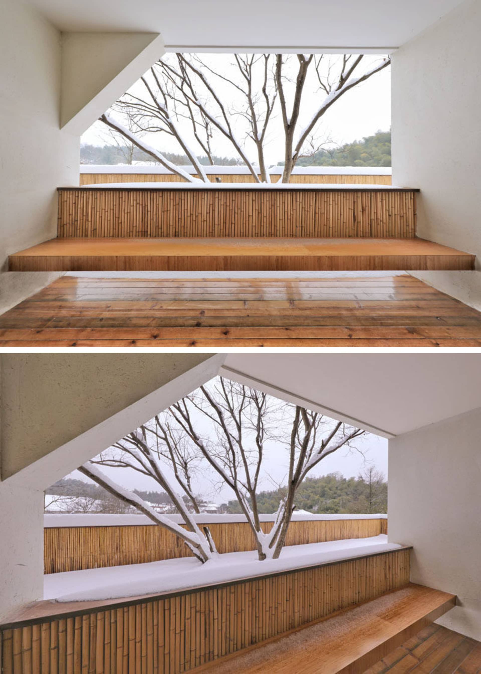 A modern architectural staircase with wooden steps and a wooden railing, featuring a view of a snowy tree.