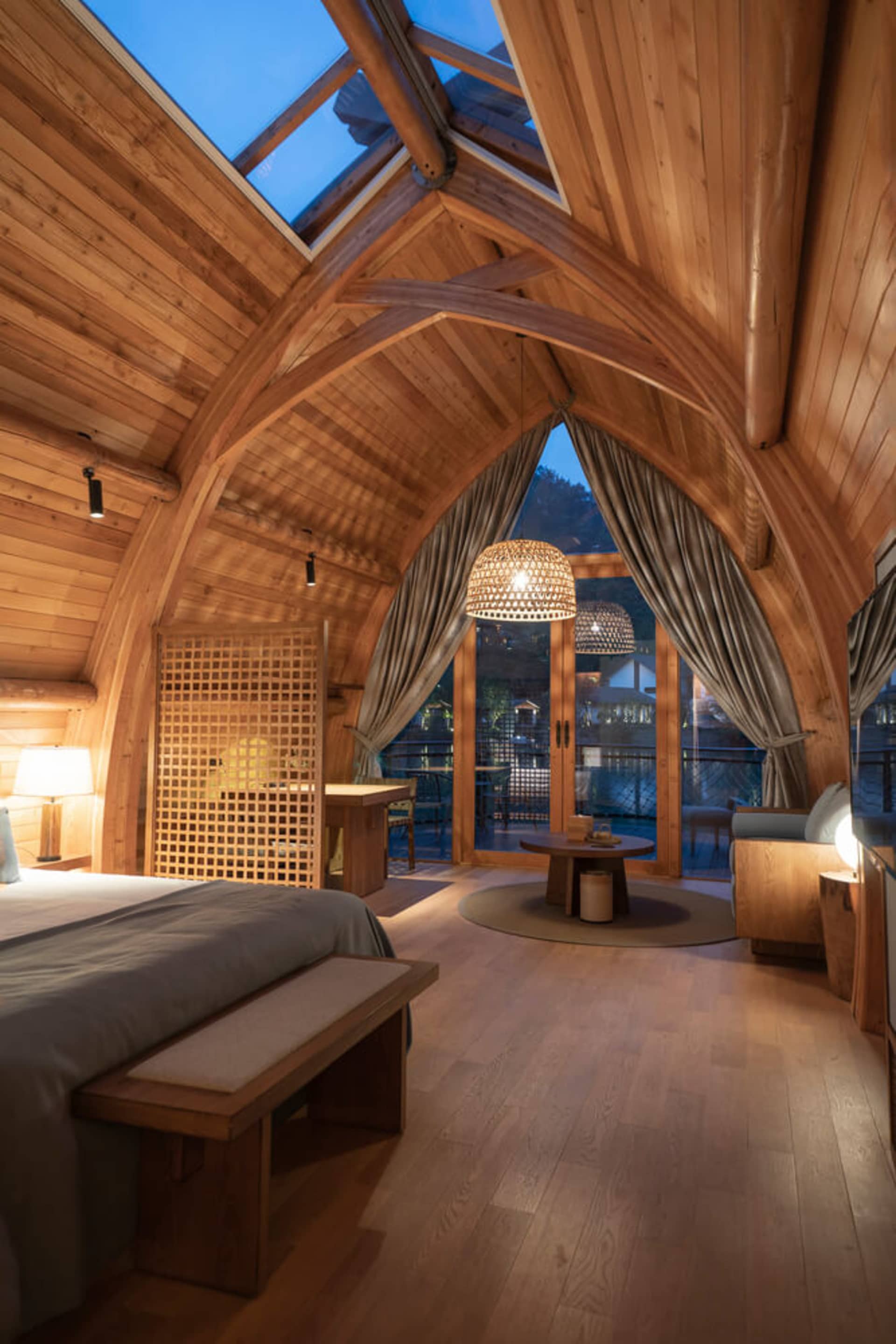 A bedroom featuring wooden walls, glass door, and industrial design elements.