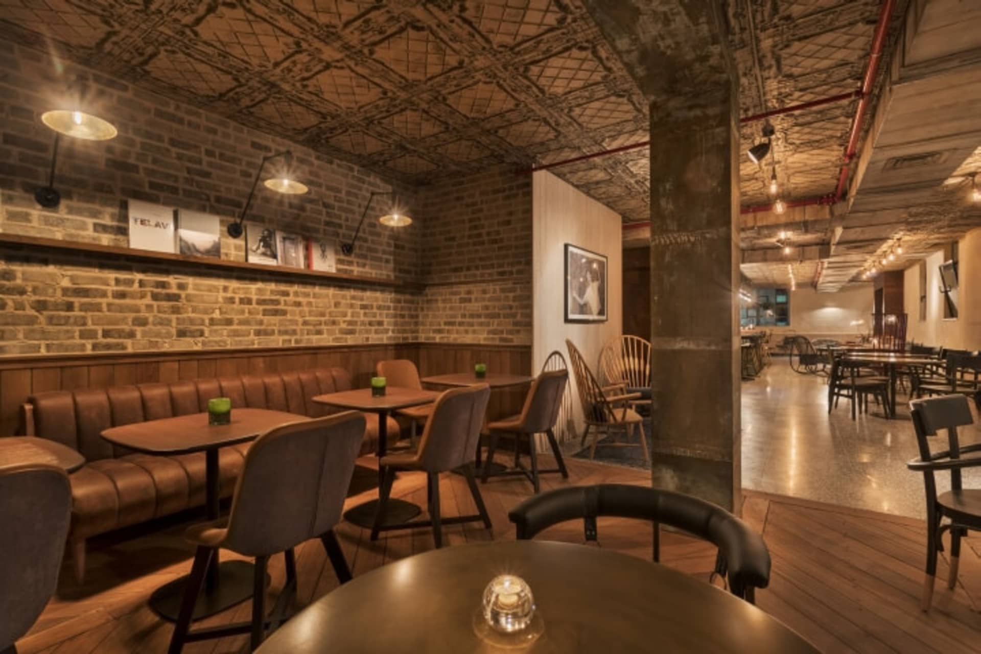 工業風餐廳,擁有磚牆、皮革卡座和木製餐桌。