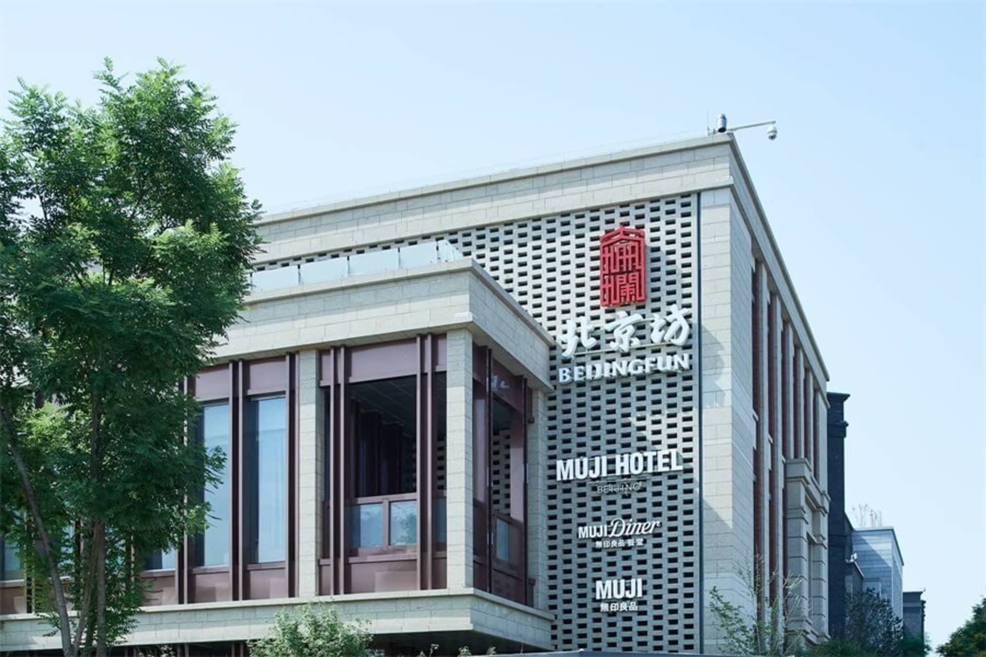 Modern commercial building with stone exterior, metal cladding, and glass windows.