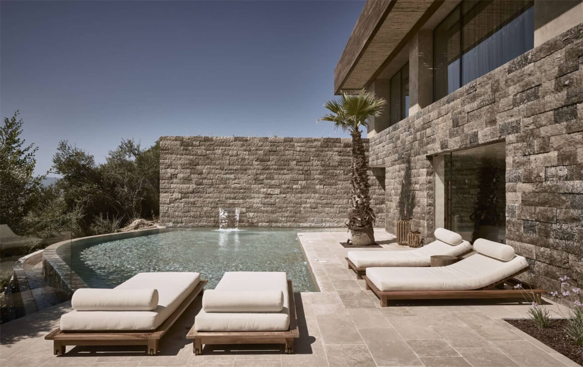 Modern residential pool with stone and concrete design features