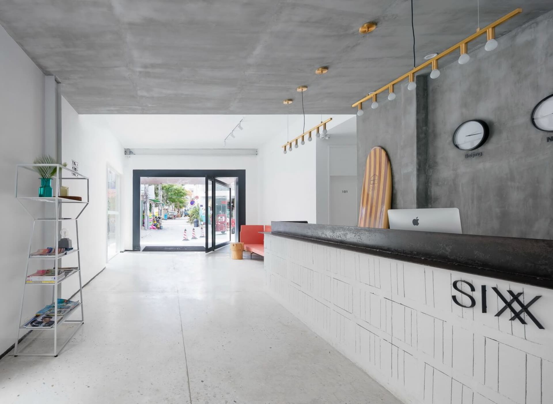 A spacious industrial-style office interior featuring white concrete walls and floors.