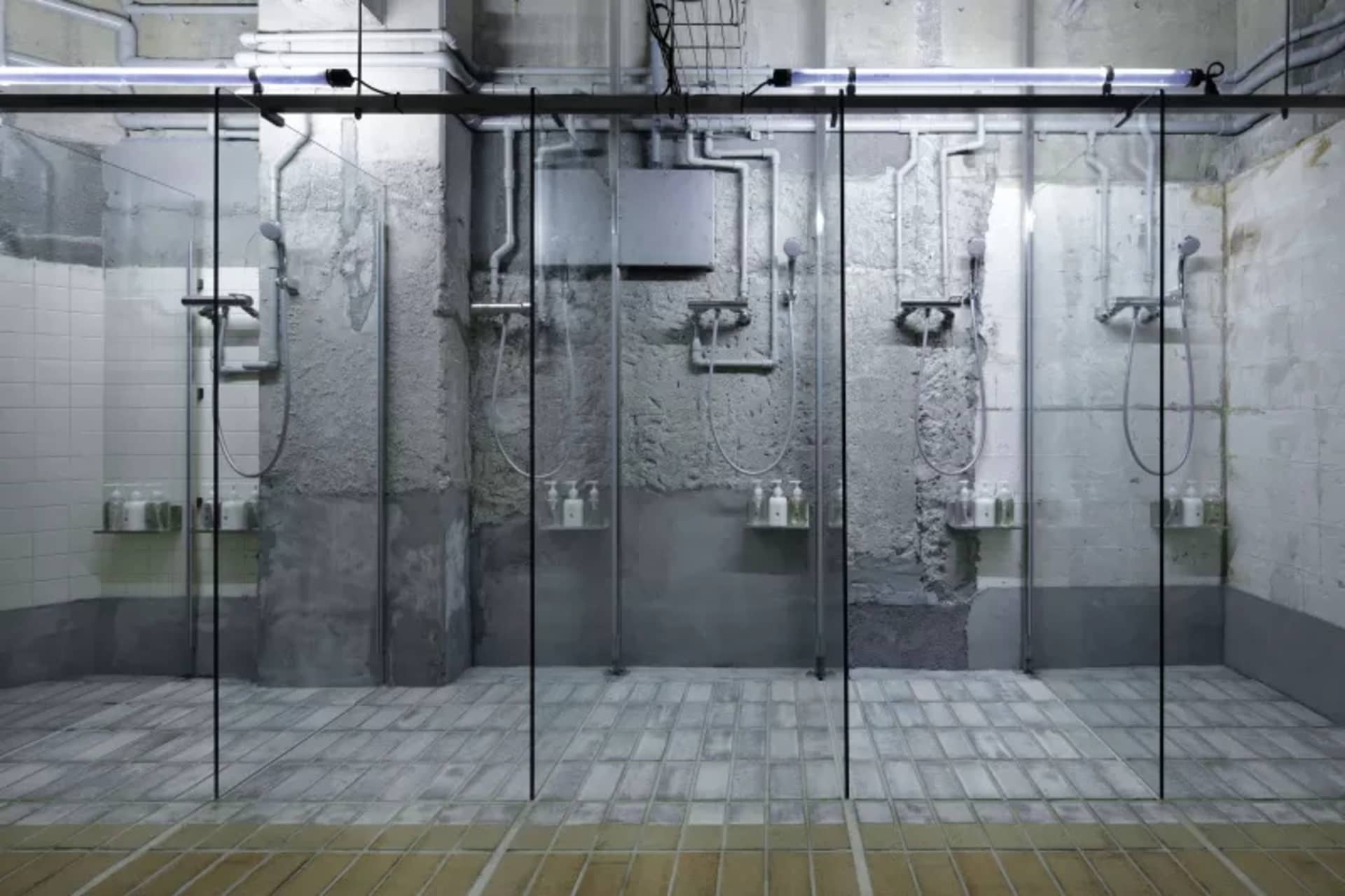 Industrial-style shower rooms featuring concrete and glass materials.