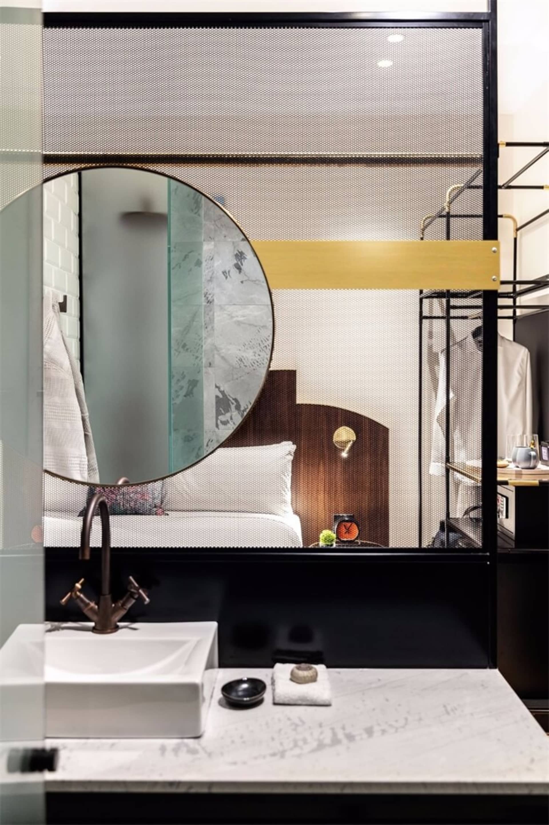 現代極簡浴室，搭配金屬點綴、玻璃隔間與大理石表面。