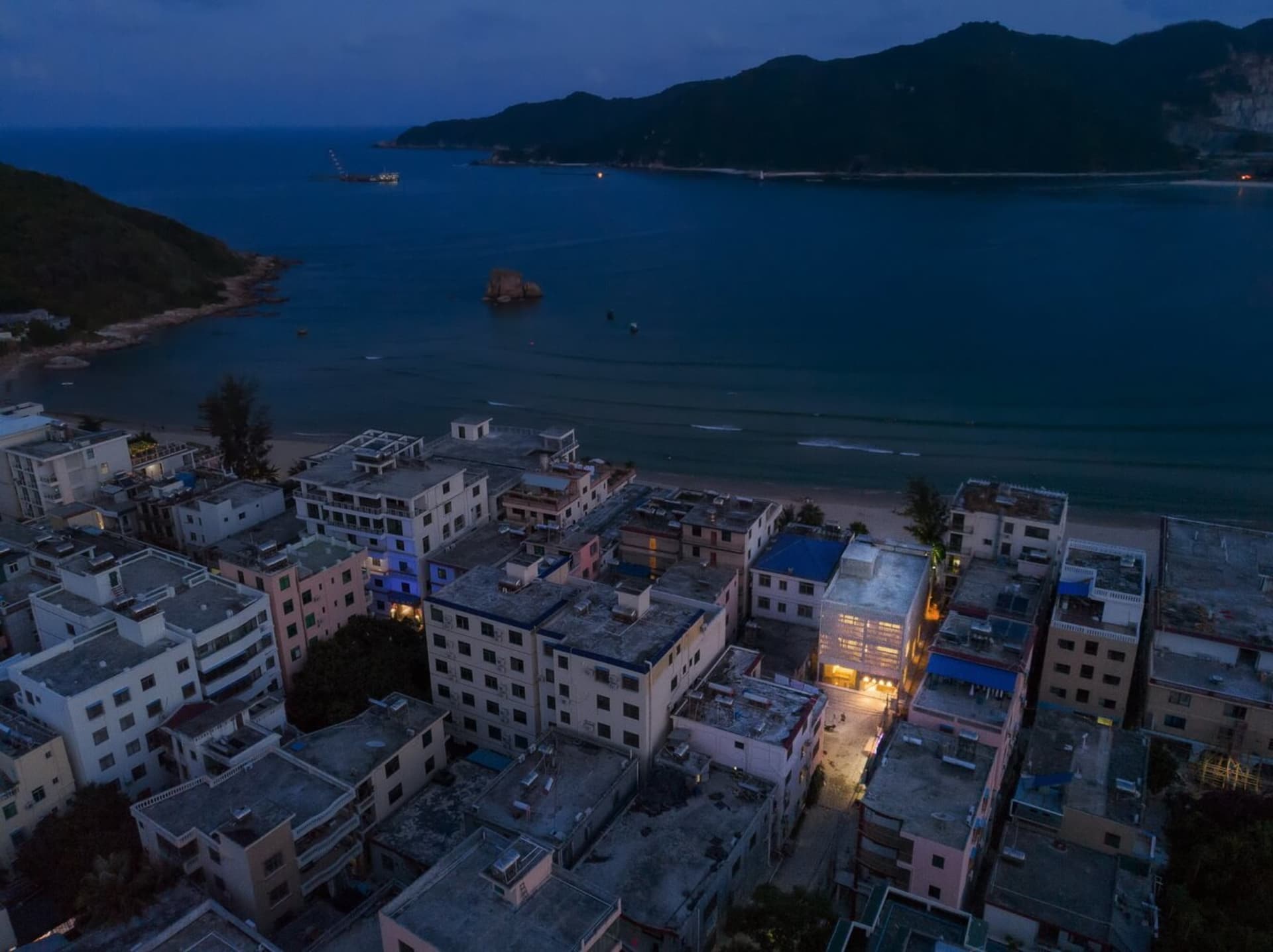 俯瞰現代建築設計，混凝土結構坐落於水邊。