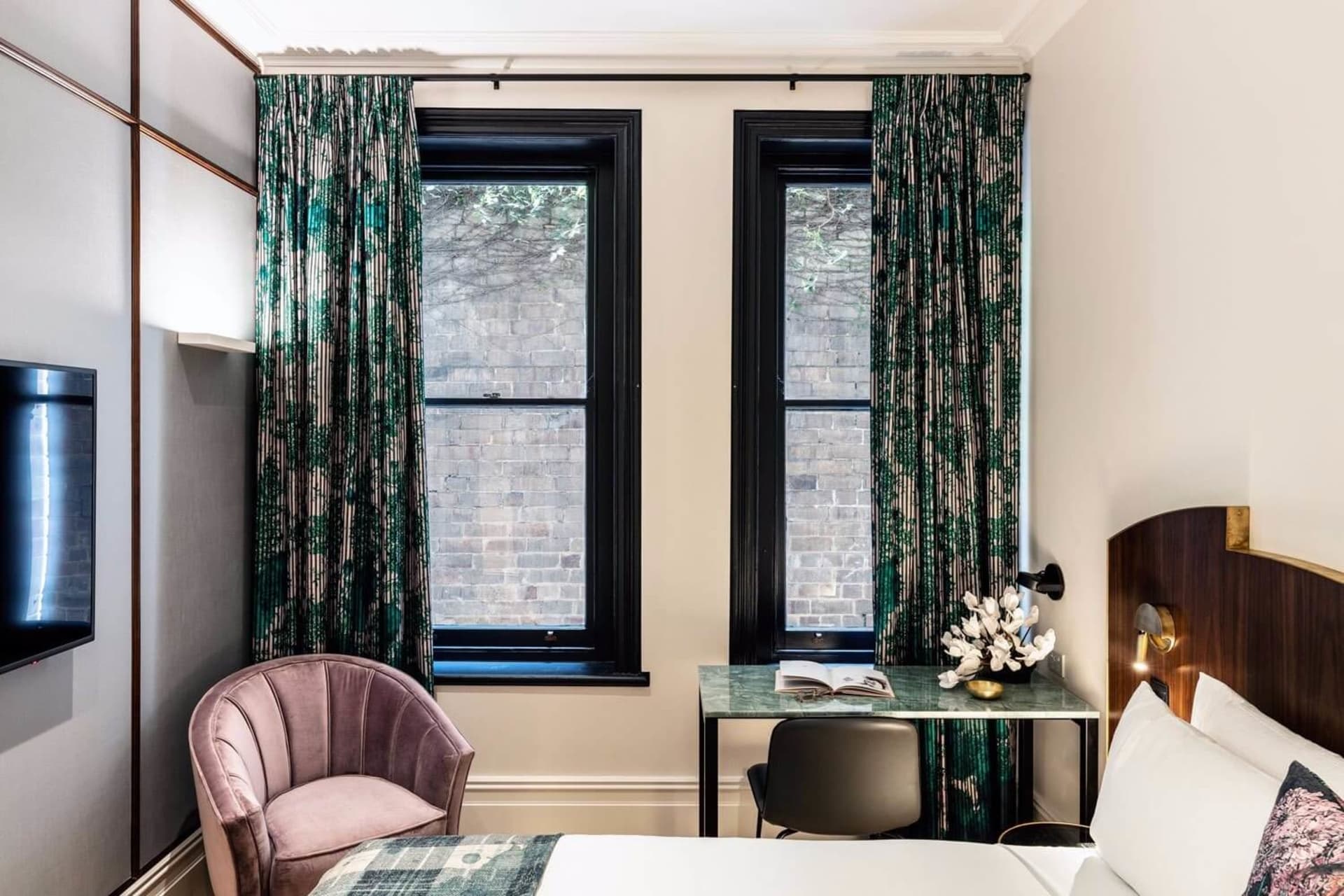 A modern bedroom featuring textured curtains and a marble-topped table.