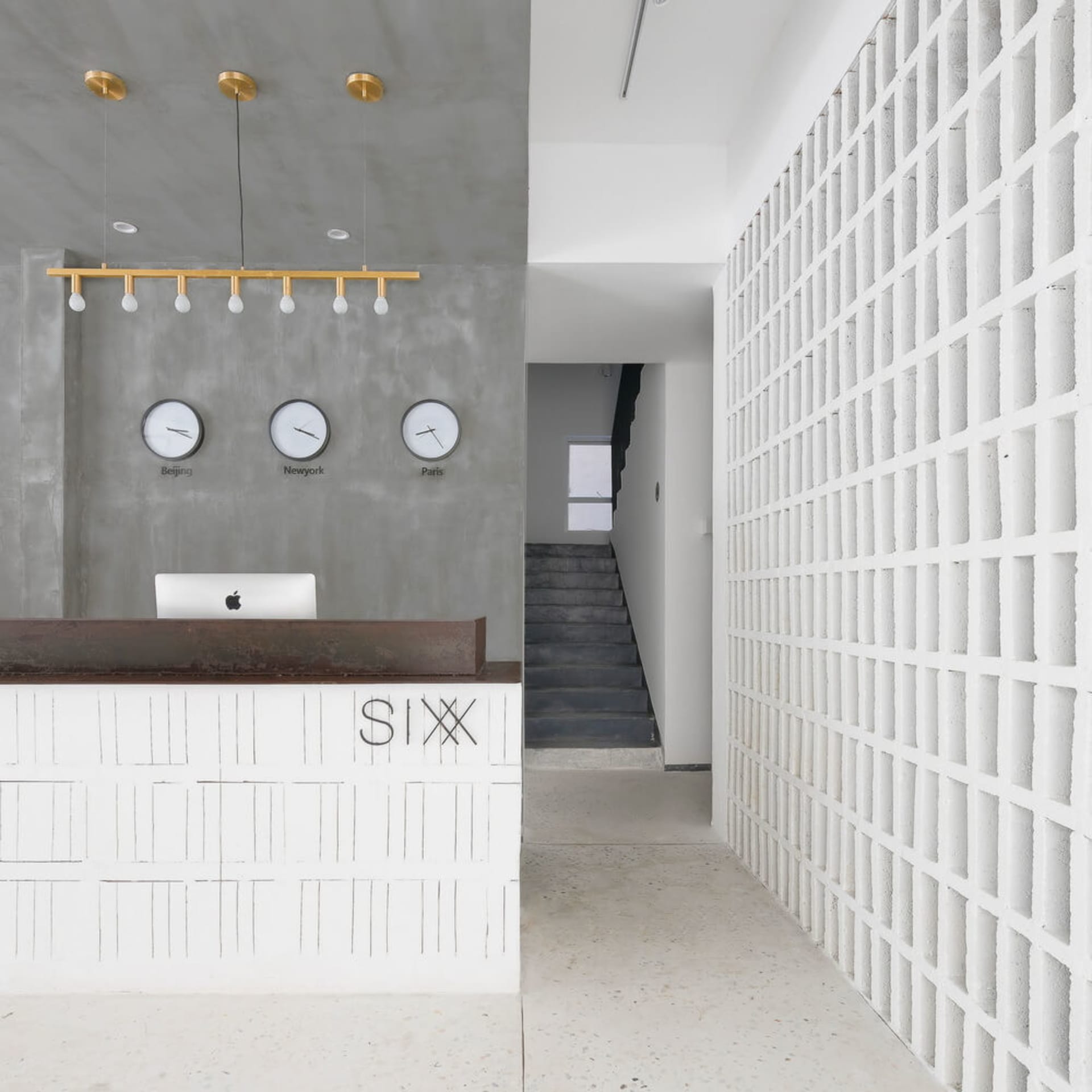 A modern minimalist lobby with concrete walls and a reception desk.