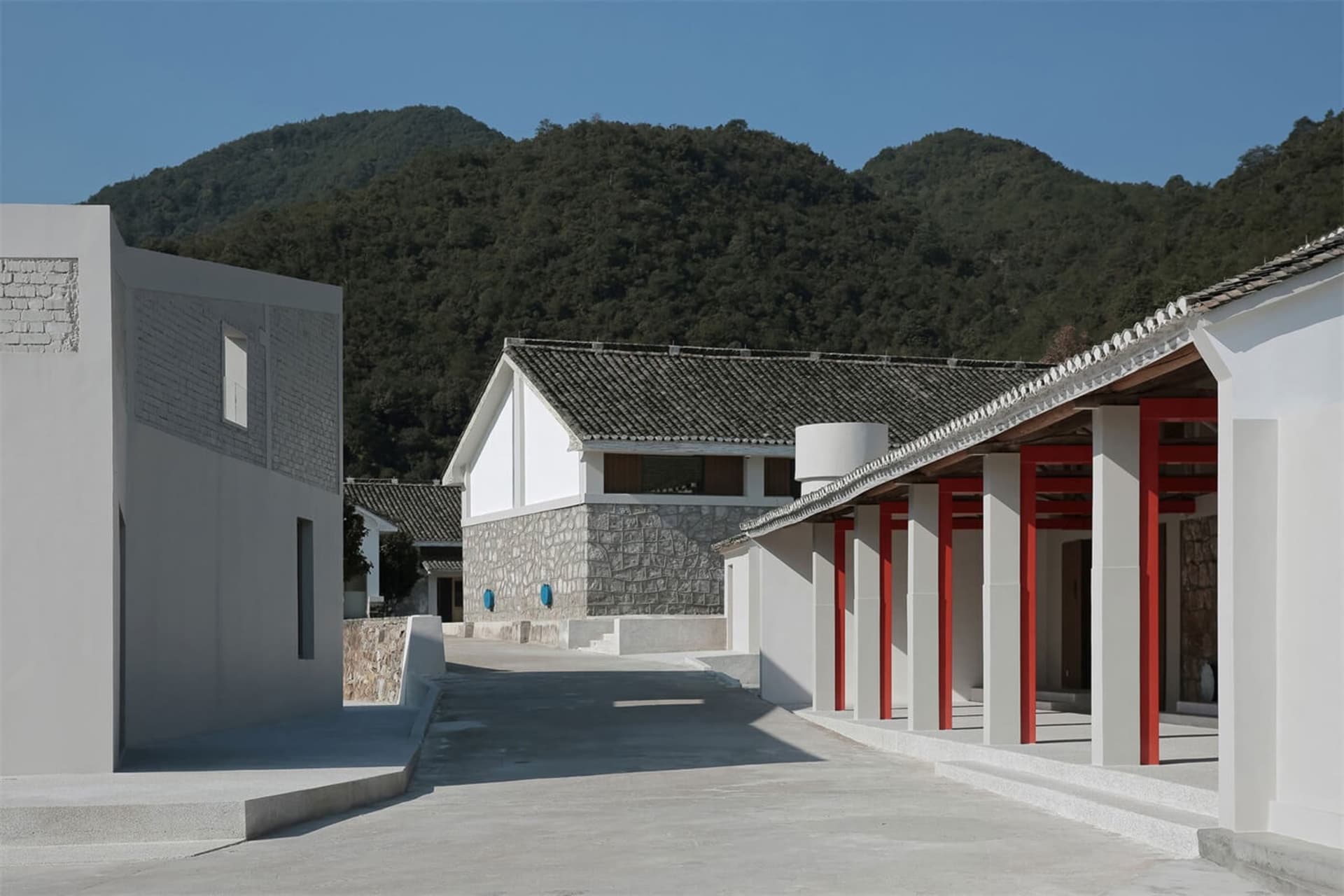一棟現代住宅,擁有混凝土牆面與紅色柱子。