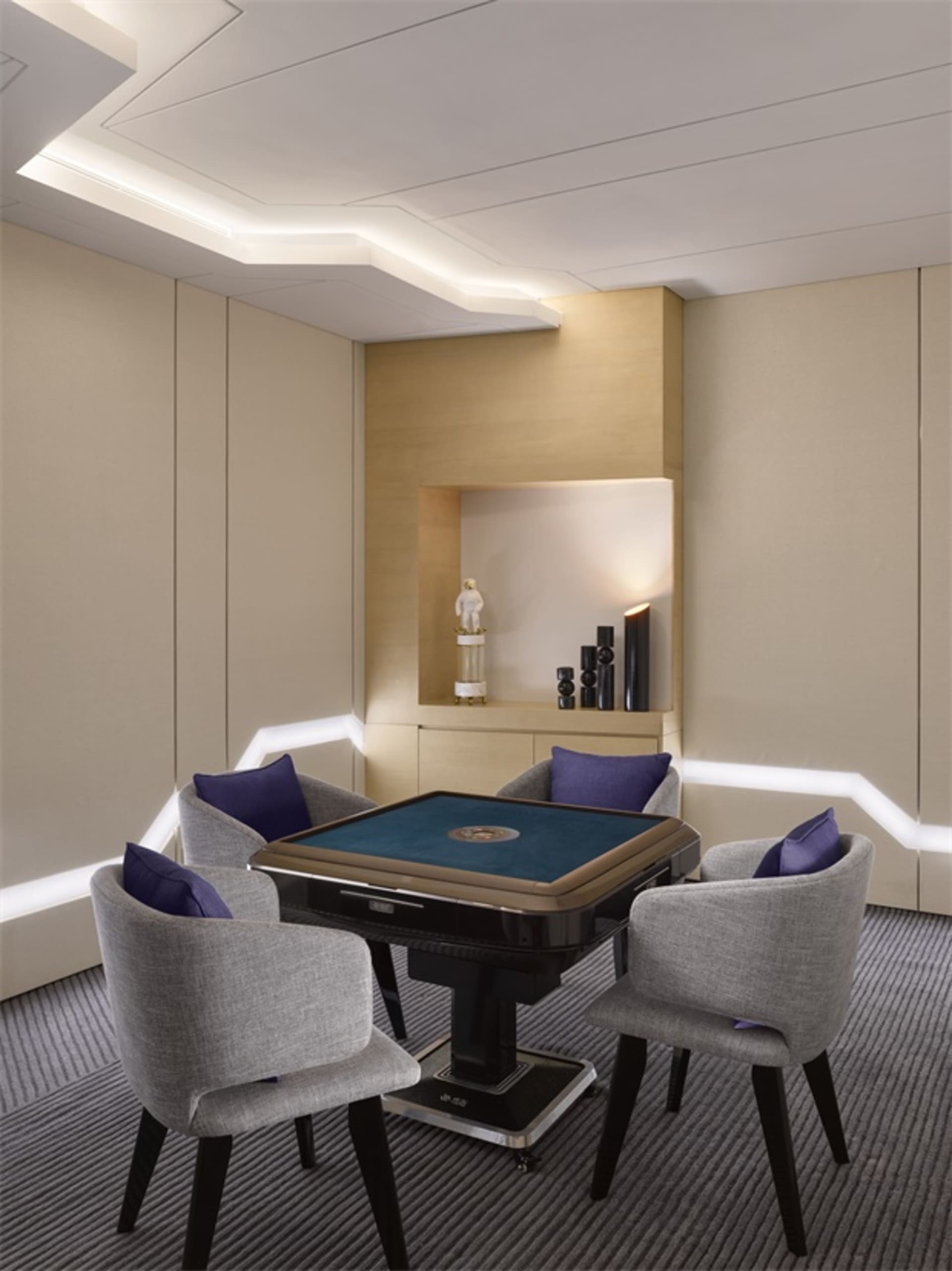 A modern minimalist gaming room with fabric chairs, a wooden table, and glass accents.