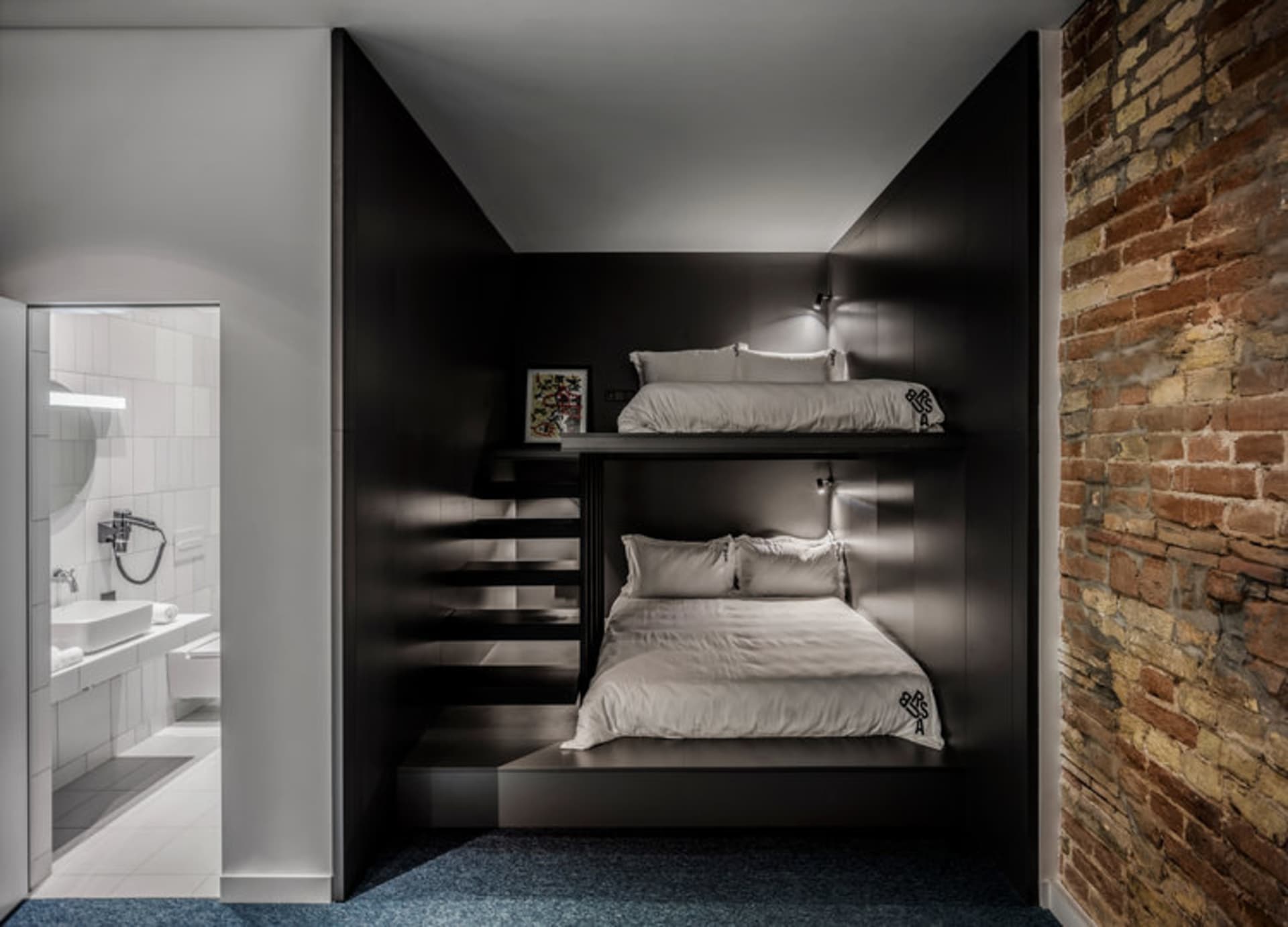 A modern bedroom with industrial elements, featuring concrete walls and a bunk bed design.