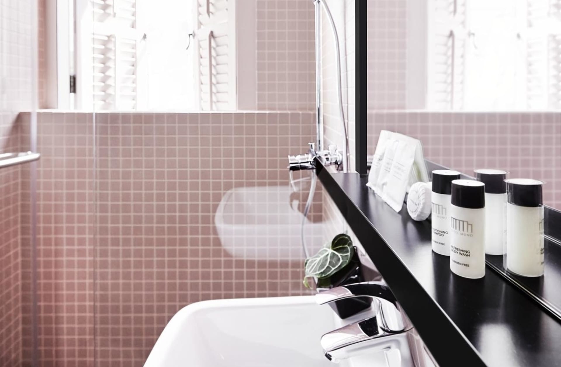 Contemporary bathroom featuring minimalist design with white fixtures and ceramic tile walls.