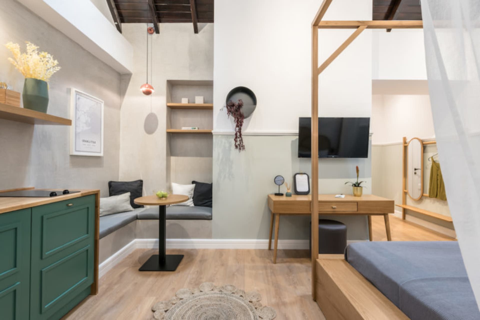 Minimalist living room with wood furniture, grey couch, and round rug.