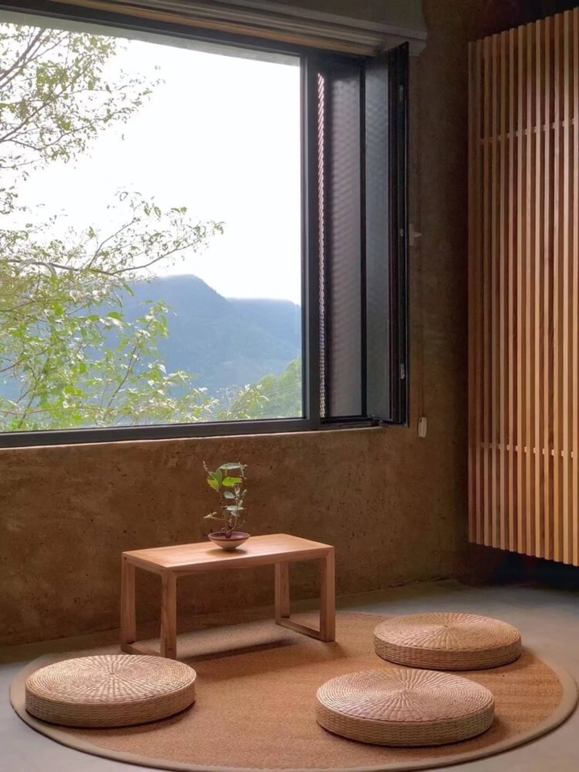 A modern indoor living space featuring concrete walls and wooden furniture.