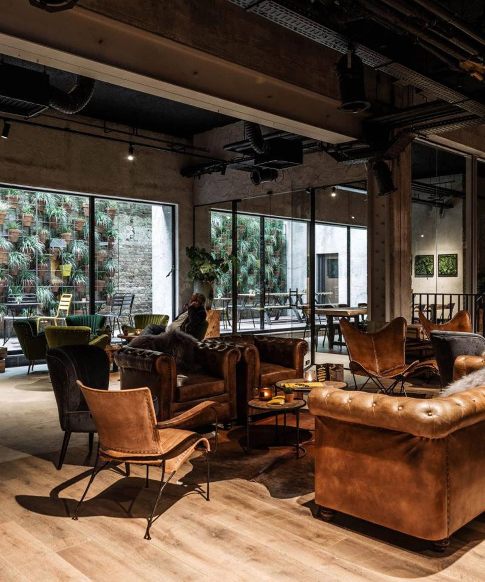 Industrial-style cafe with concrete walls, leather furniture, and wooden flooring.