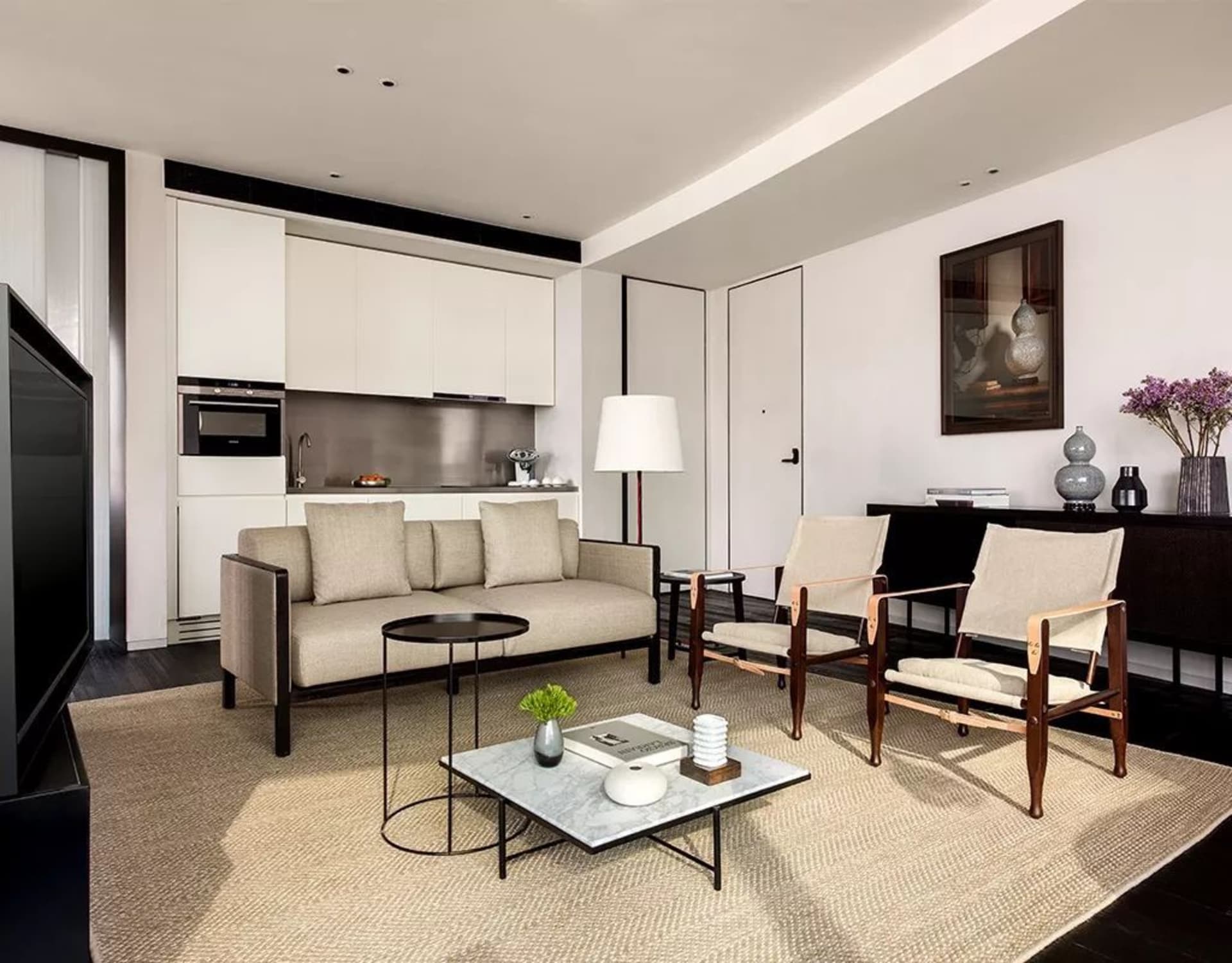Minimalist residential living space featuring neutral-toned upholstery and wooden furniture.