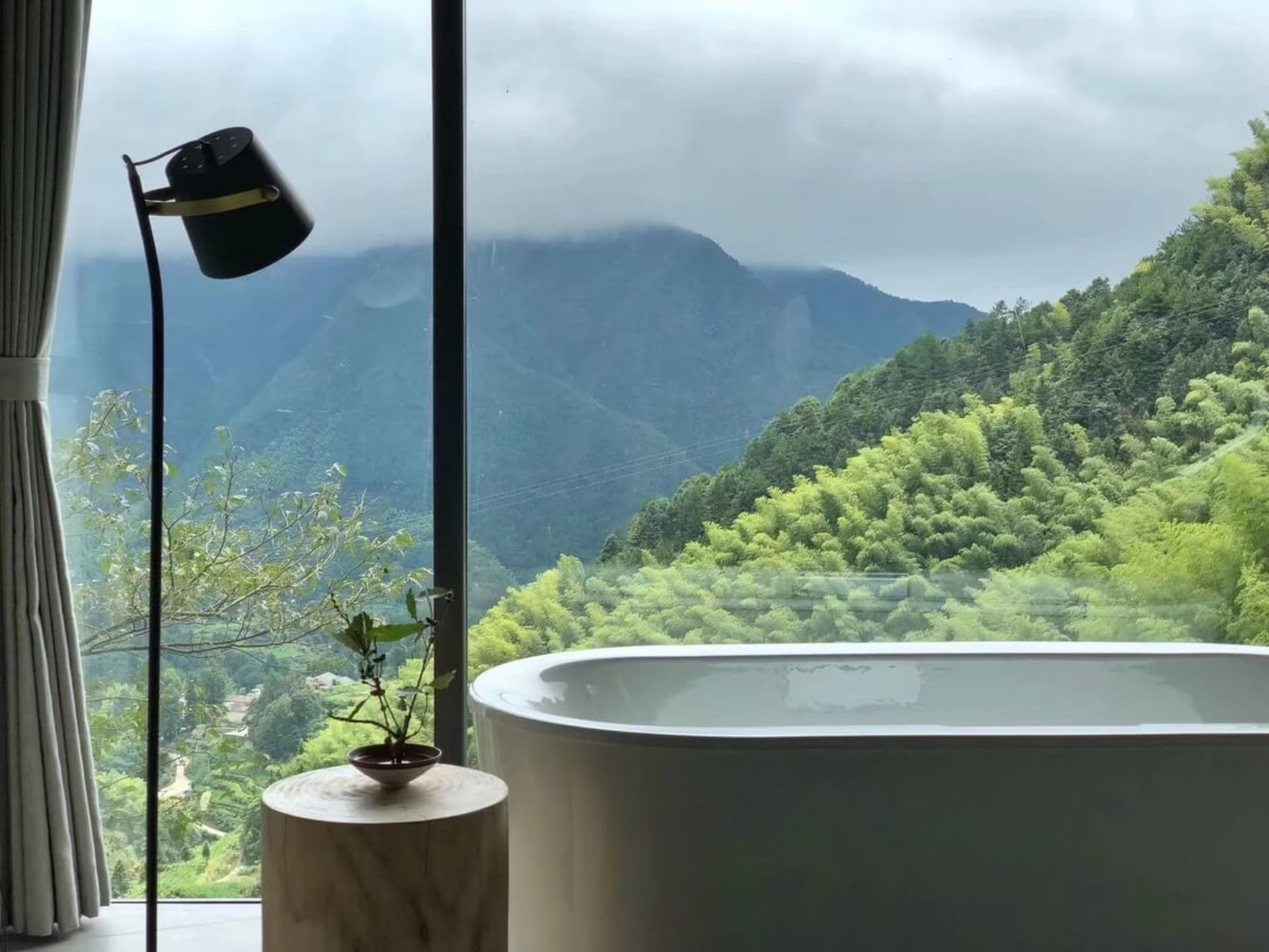 現代浴室配有玻璃牆，可俯瞰山景。
