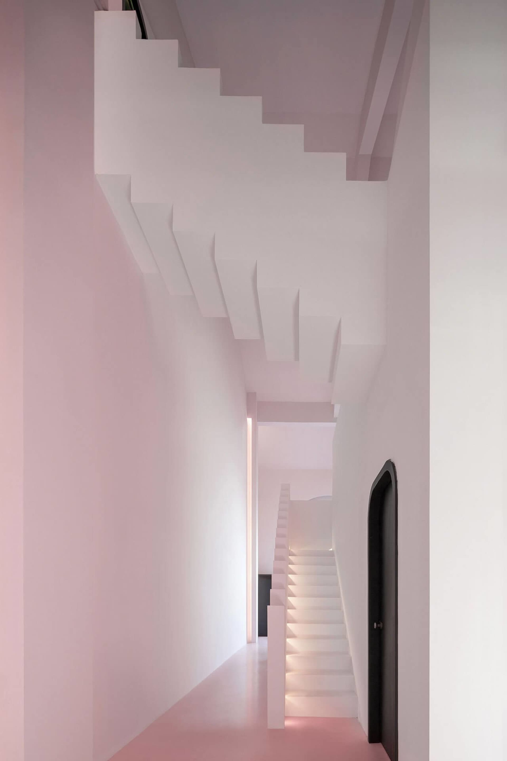 A modern interior design featuring a light pink staircase with white walls and a ceiling.