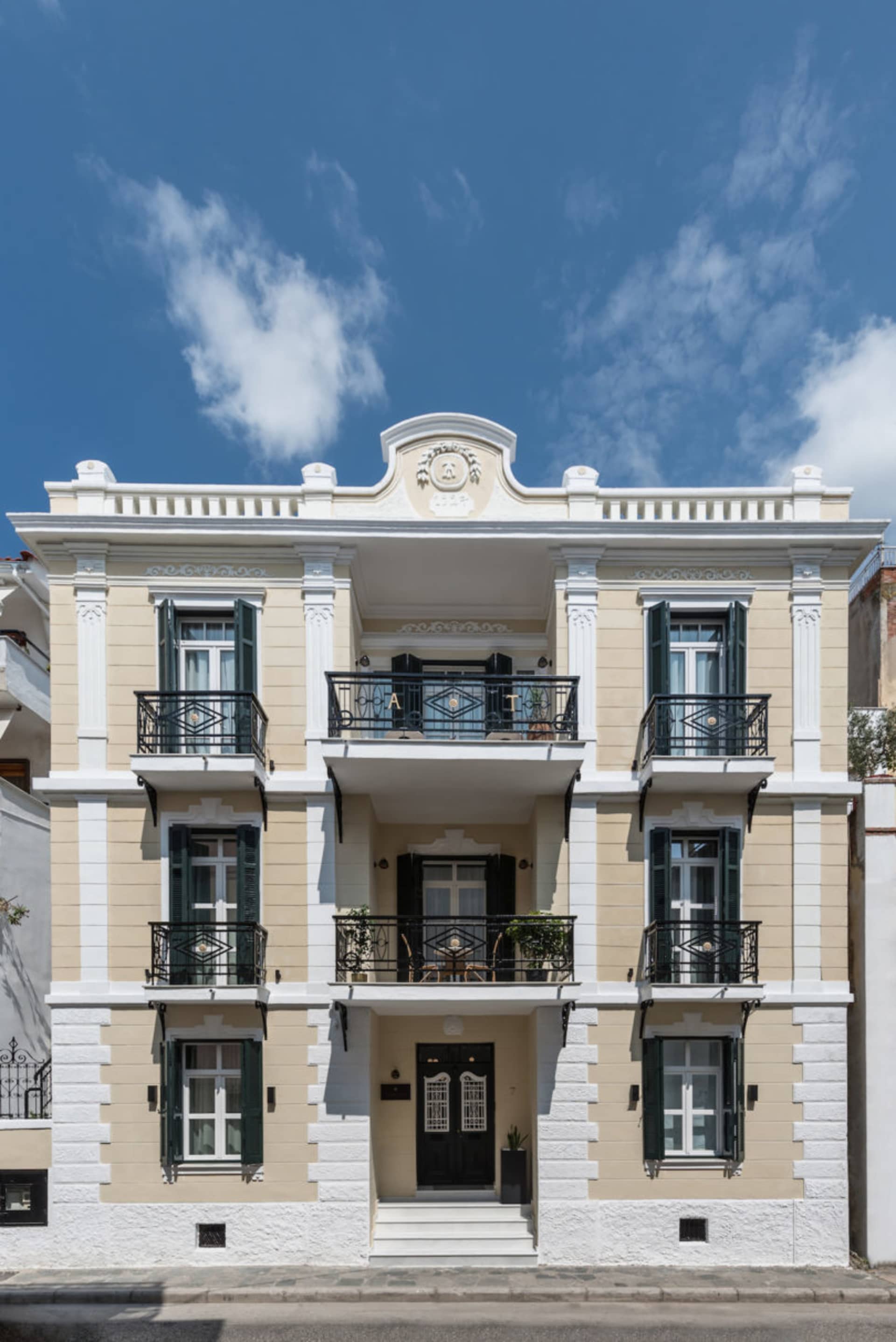 A modern residential building with concrete walls and white stucco finish.