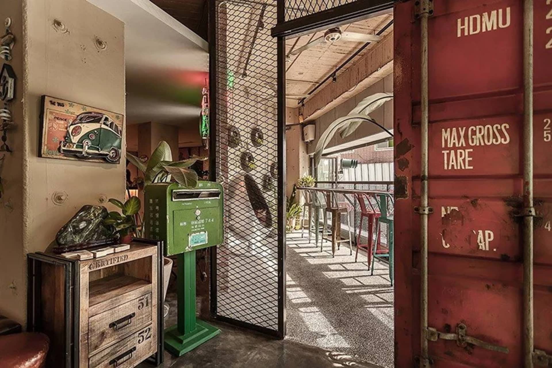 Industrial-style restaurant interior featuring a metal shipping container and rustic elements.