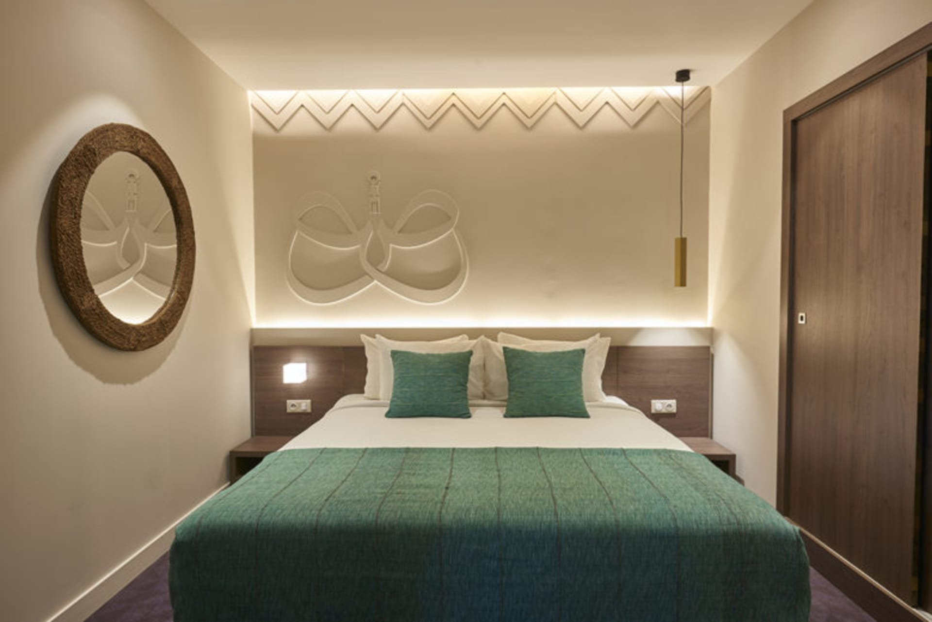 A modern bedroom featuring a textured bed and geometric wall design.