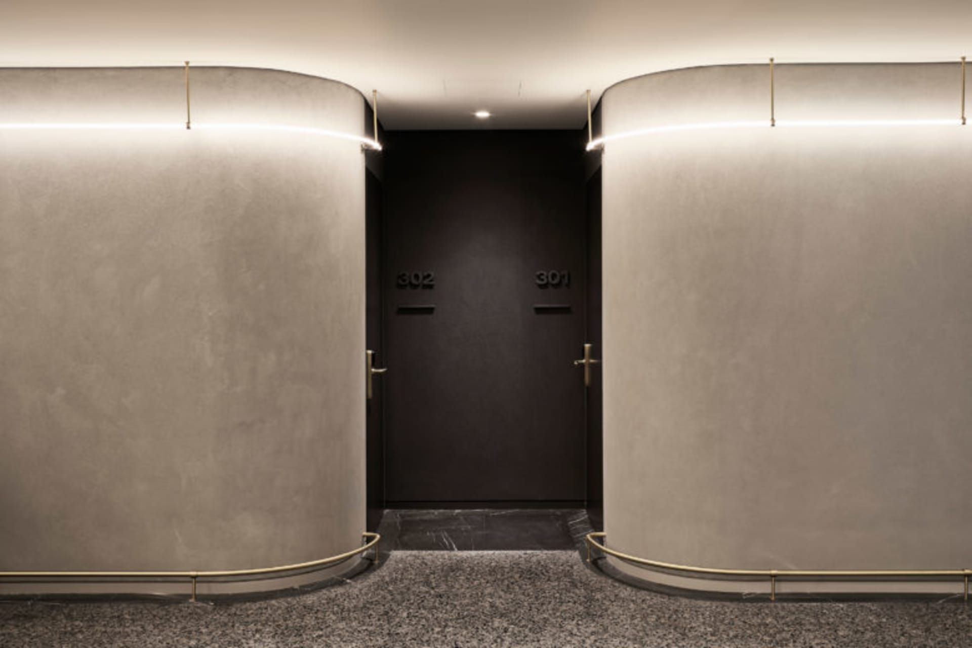 A modern lobby with concrete walls and recessed lighting.