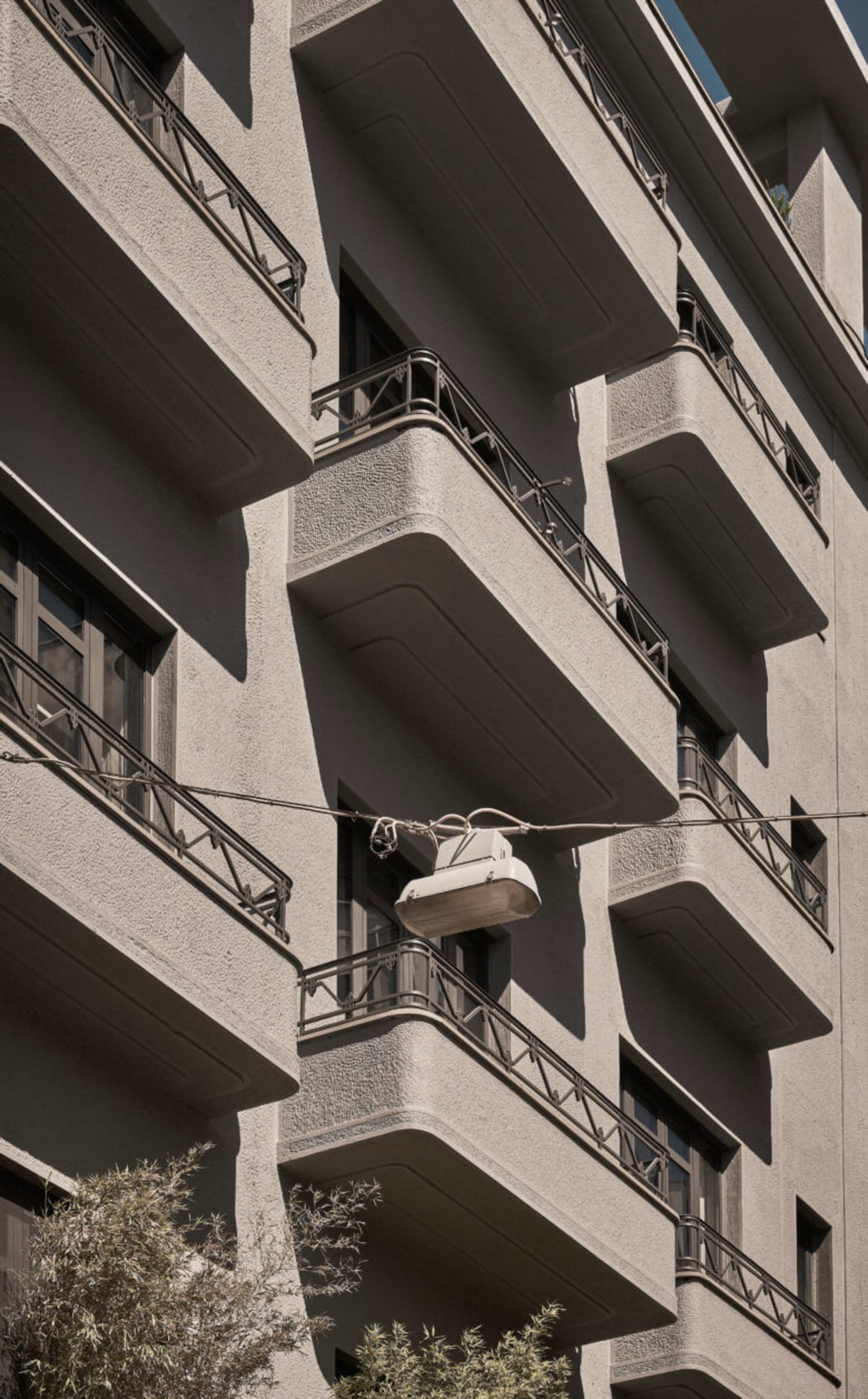 混凝土建築搭配陽台,街燈懸掛在電線上
