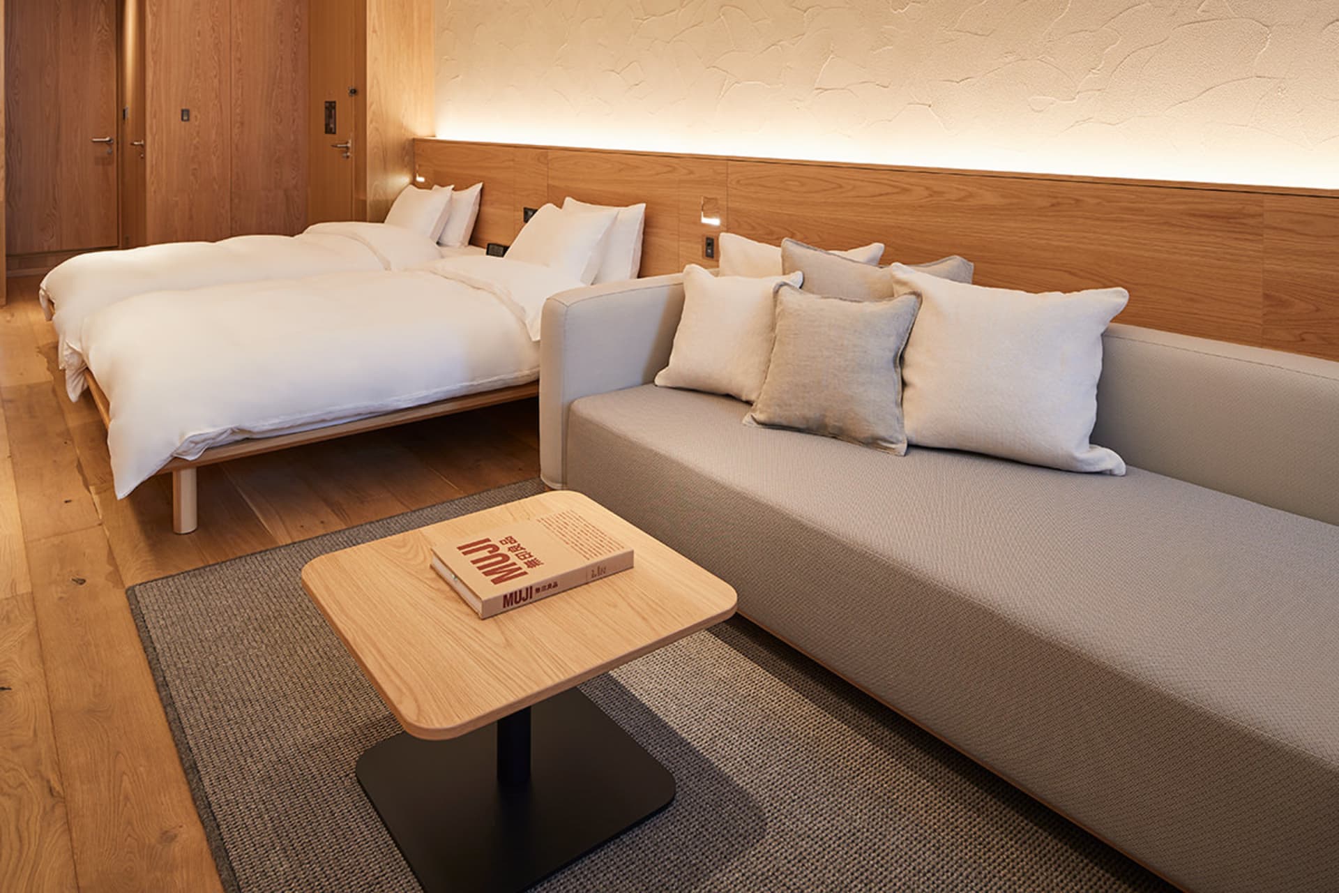 Modern living room with a coffee table, couch, and twin beds.