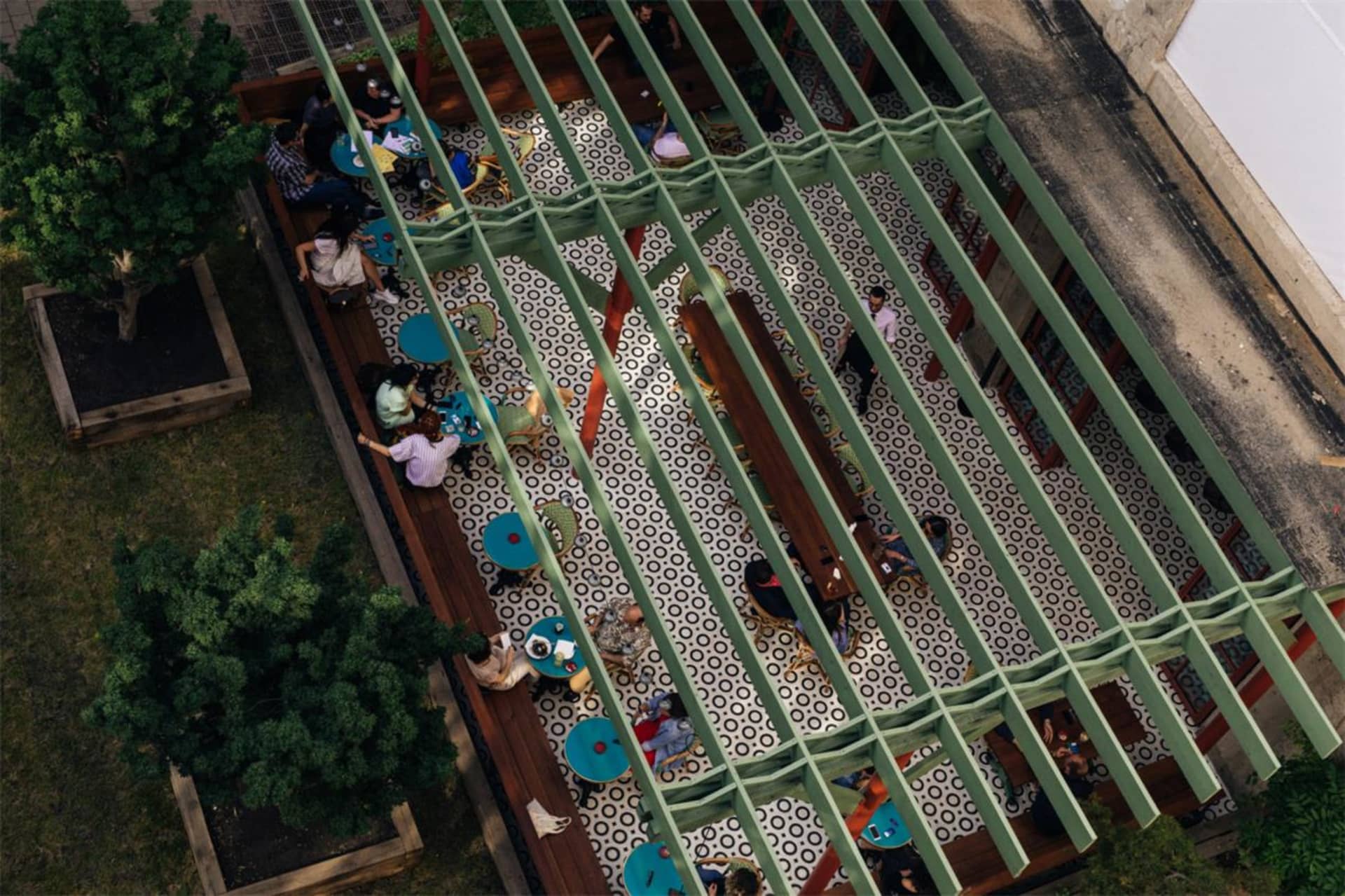 Indoor cafe decorated with wooden beams, green accents, and patterned tiles