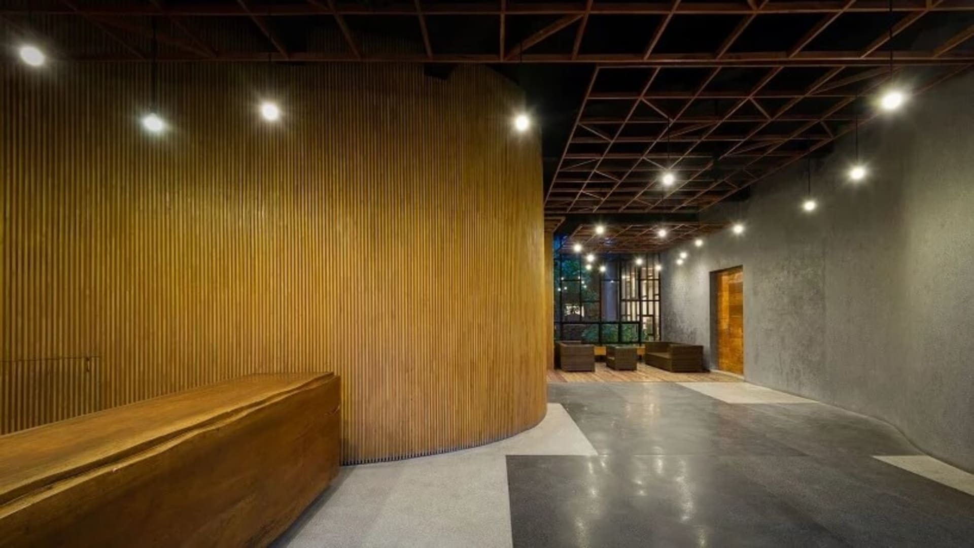 Modern office interior with concrete floors, wood walls, and industrial ceiling.