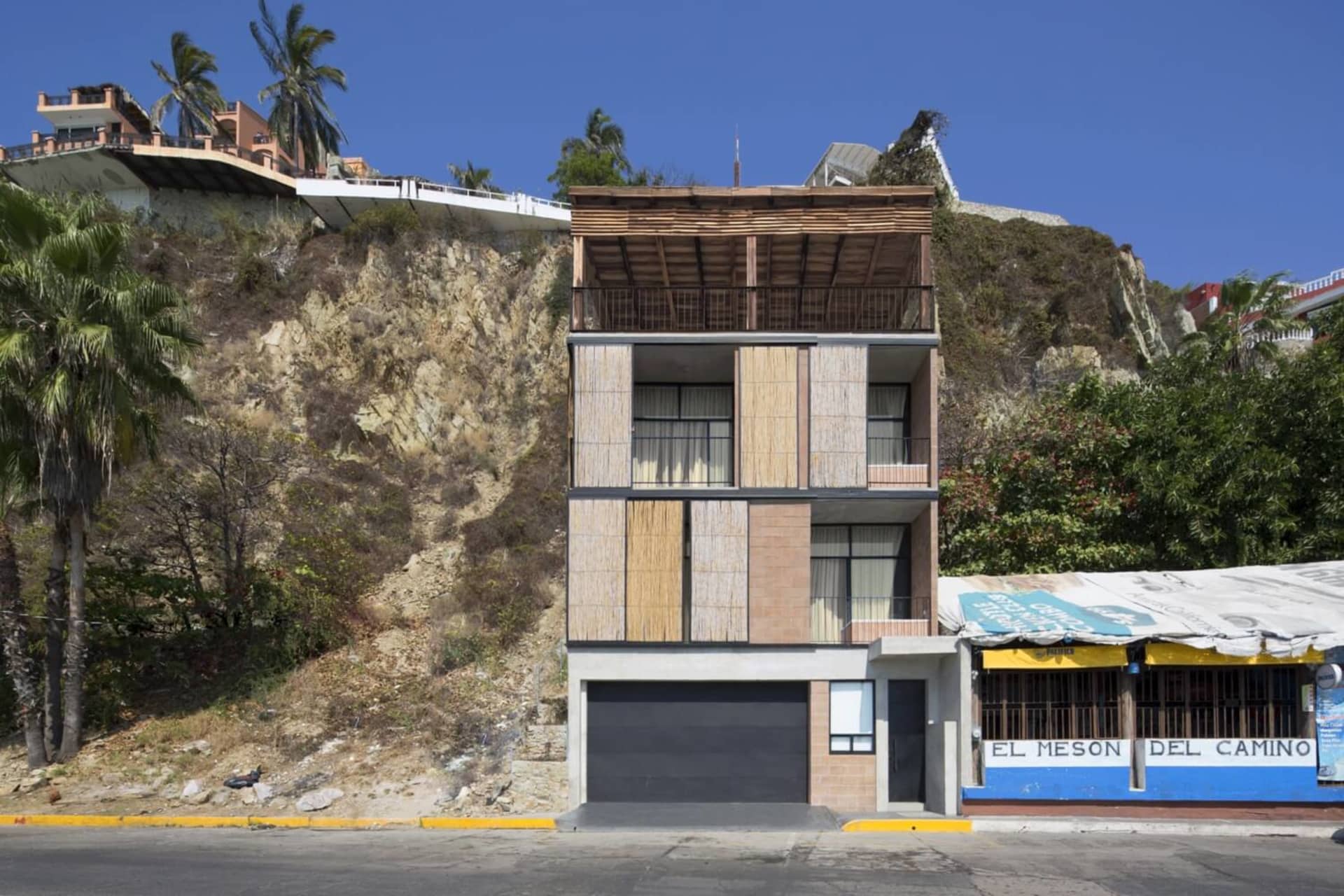 A modern residential building featuring wooden panels and concrete construction.