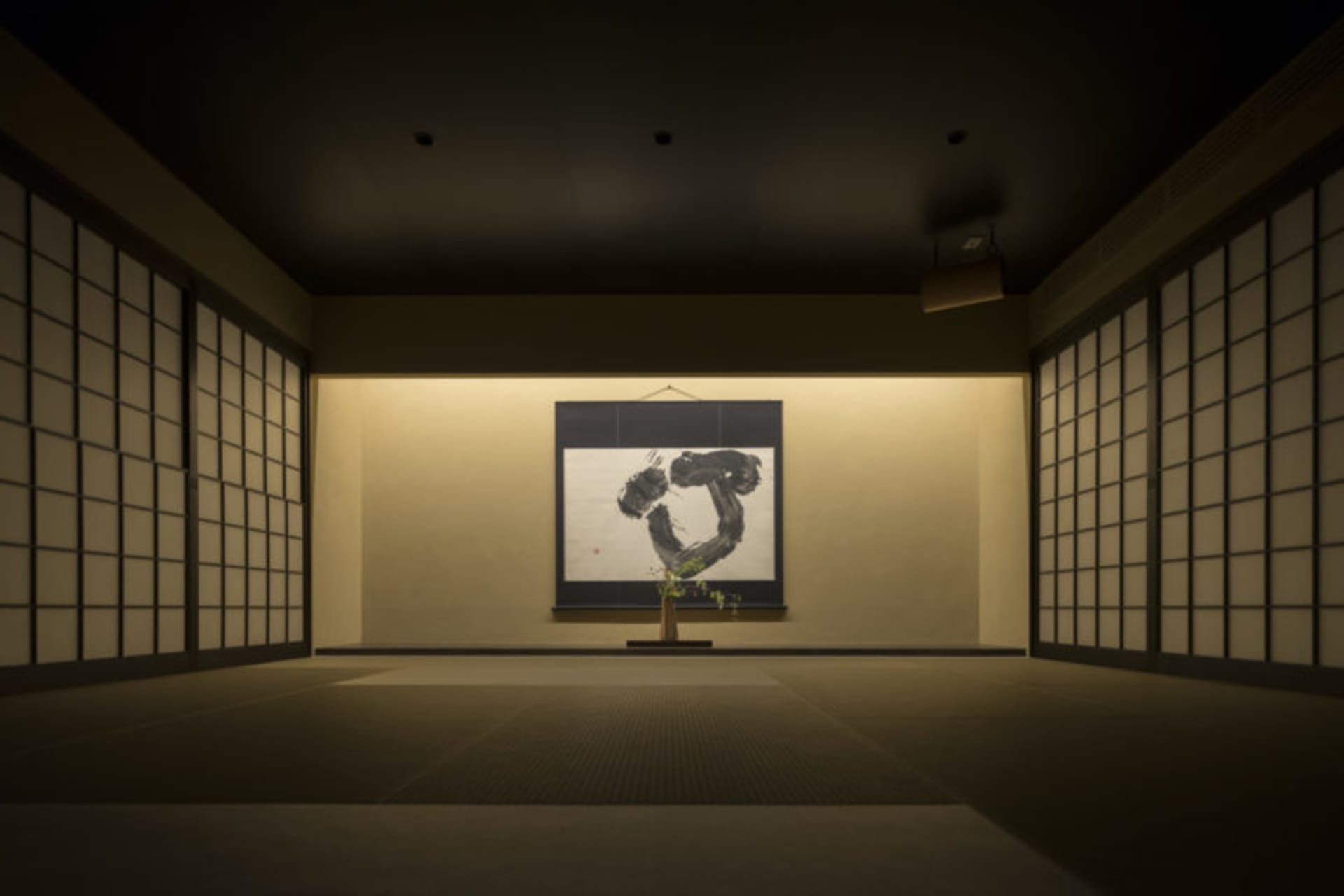 A minimalist interior features a framed piece of art displayed on a wall.