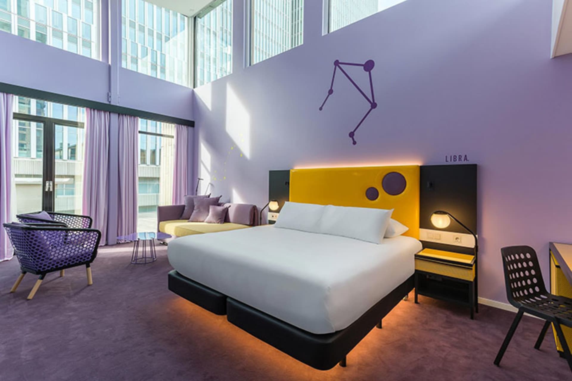 A modern bedroom featuring a purple bed with a yellow headboard, white duvet, and black nightstands.