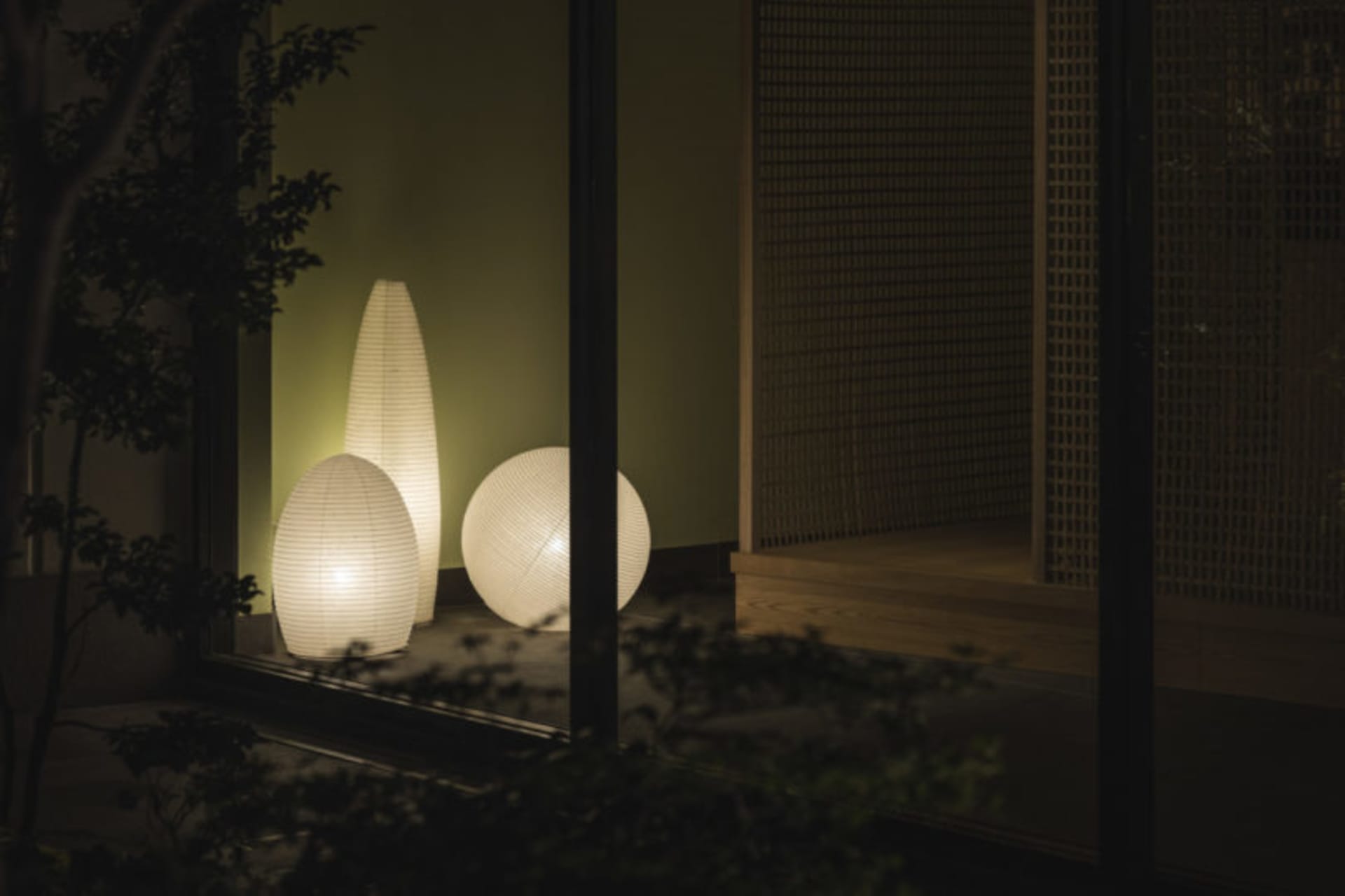 Three spherical lanterns made of paper, illuminating a living room.