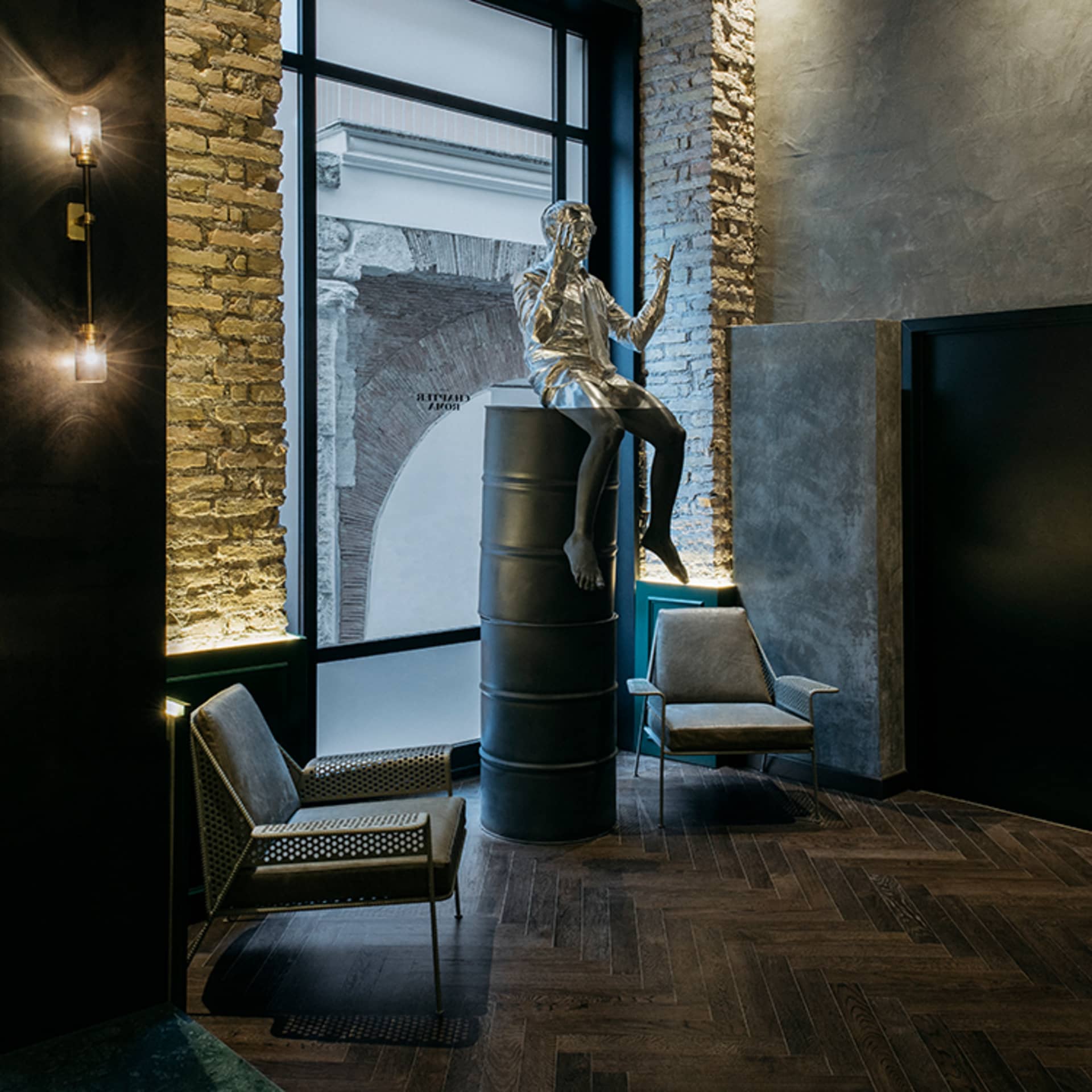 Metal statue in an industrial-style lobby with metal, stone, and glass materials