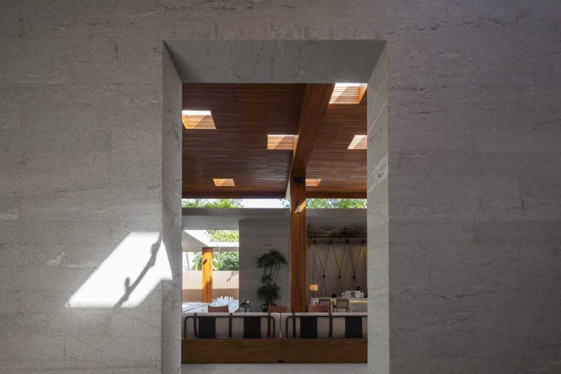 A modern indoor space featuring concrete walls and wooden ceiling panels.
