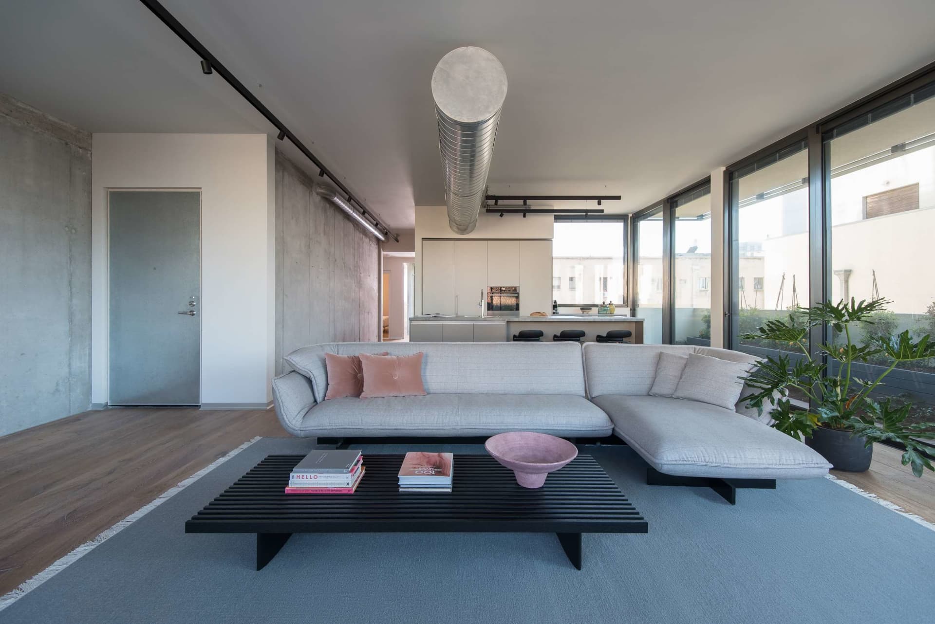 A modern living room with concrete, glass, and wooden materials.