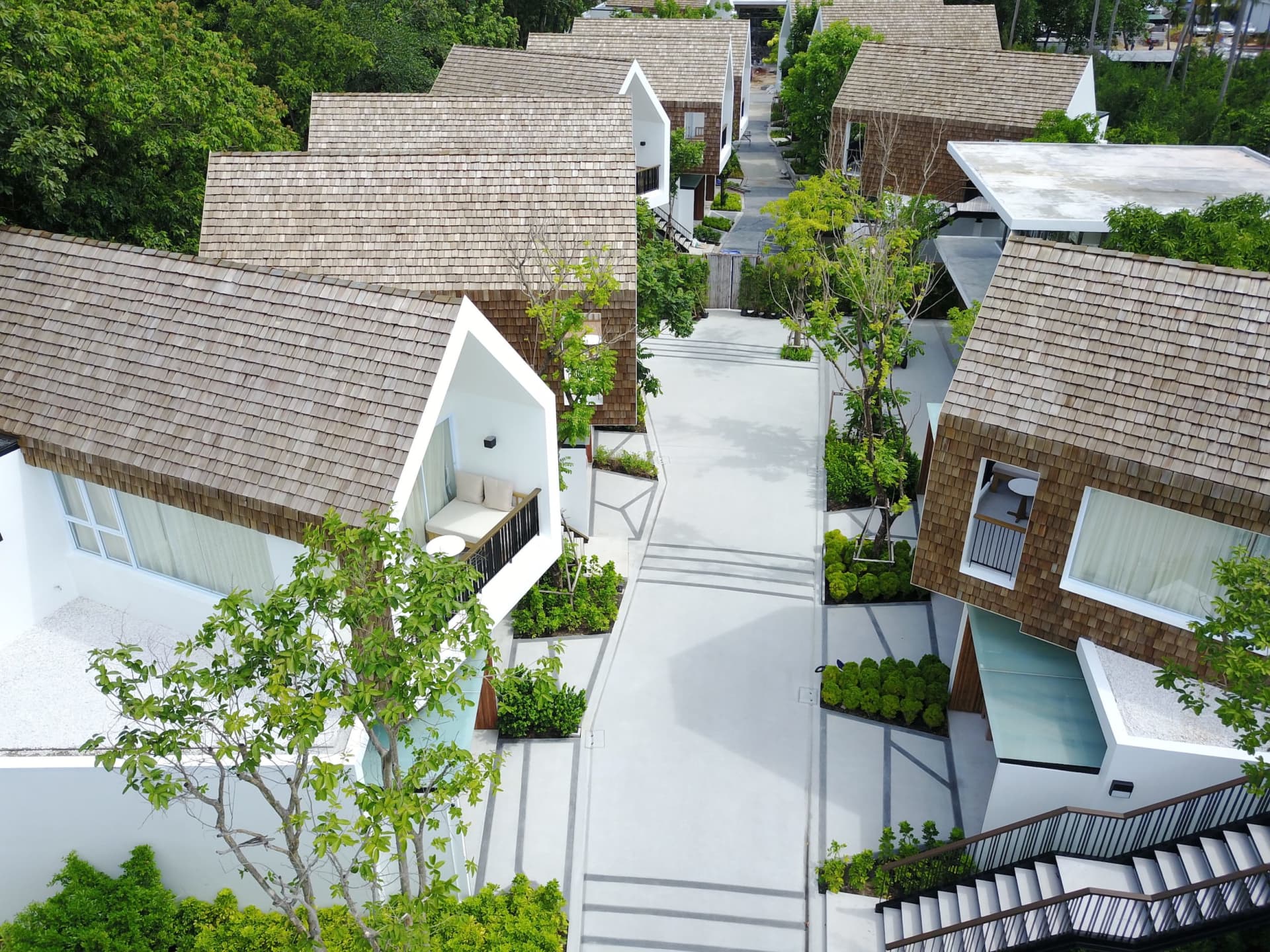 Modern residential homes with white walls, concrete structures, and glass elements.