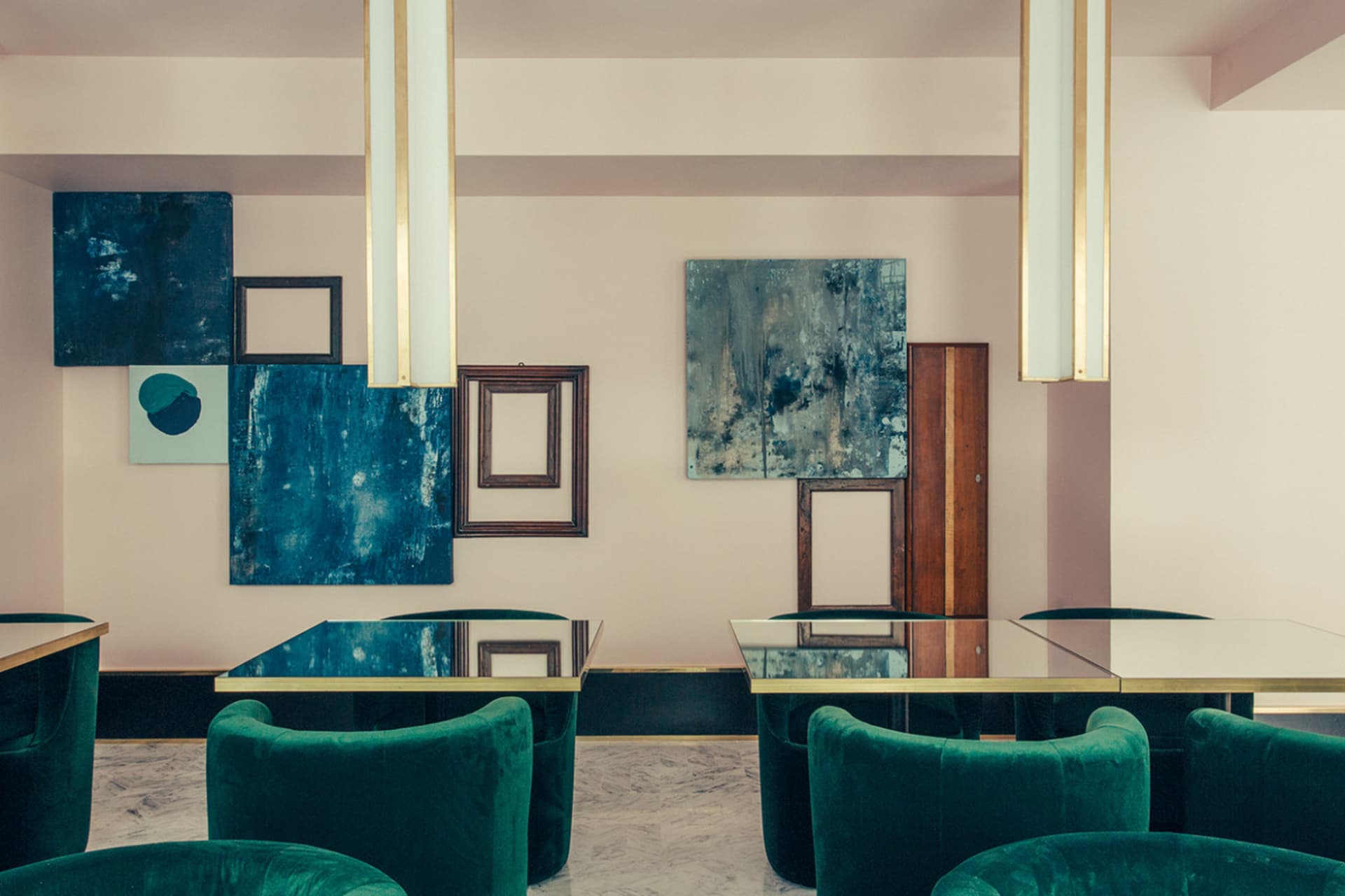 A room with modern metallic furniture and art installations, viewed from above.