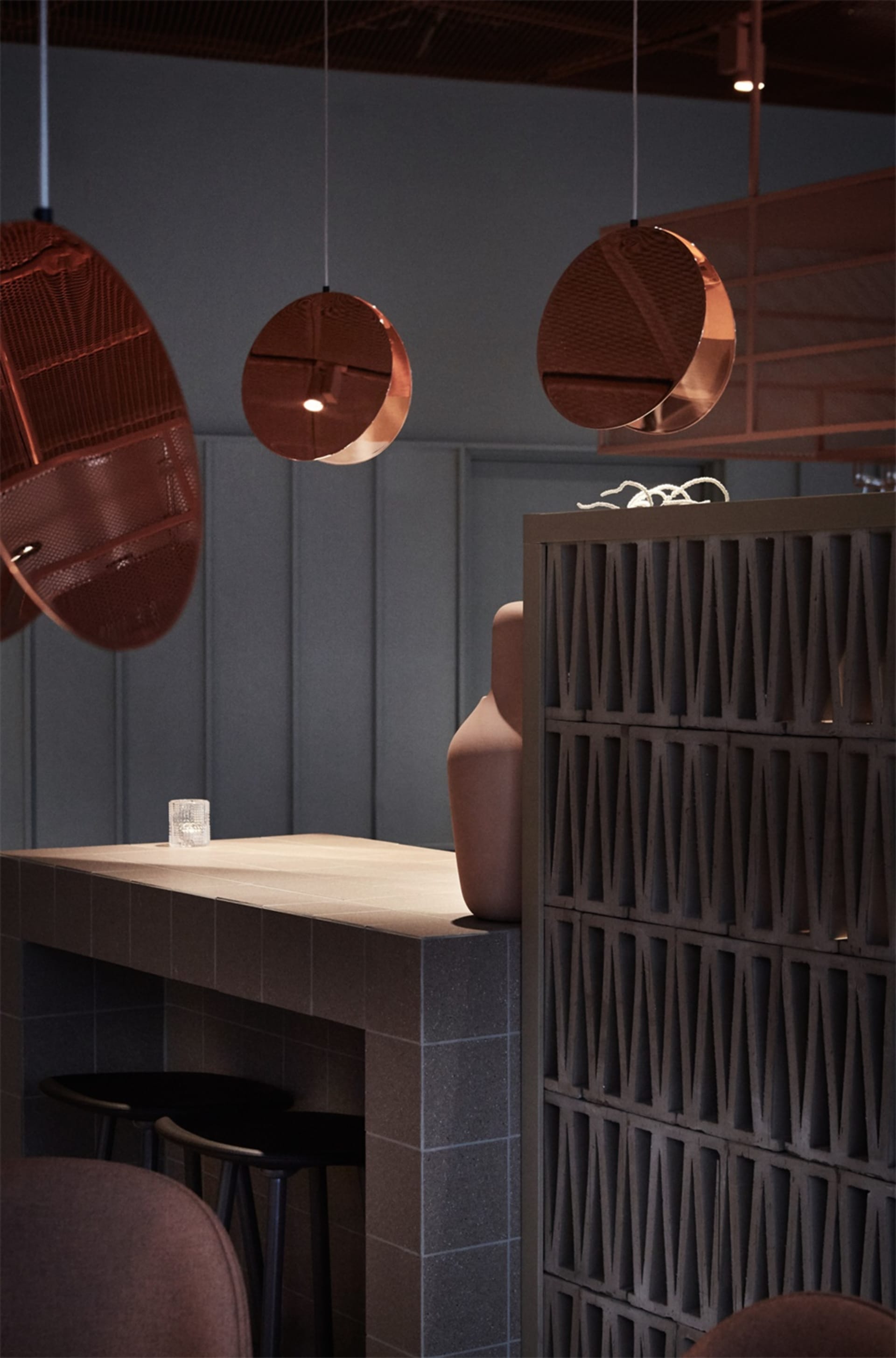Modern restaurant interior with metal counter and round lighting fixtures