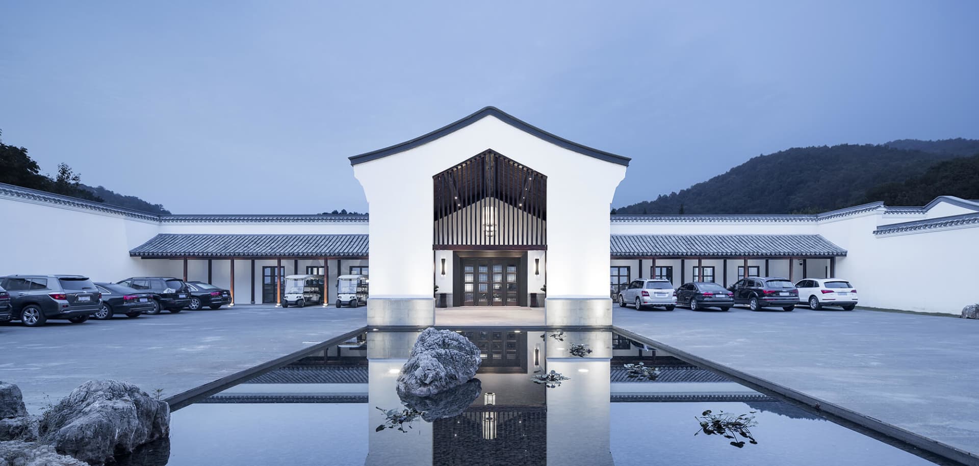 A modern residential entryway with a white cement facade and minimalist design.